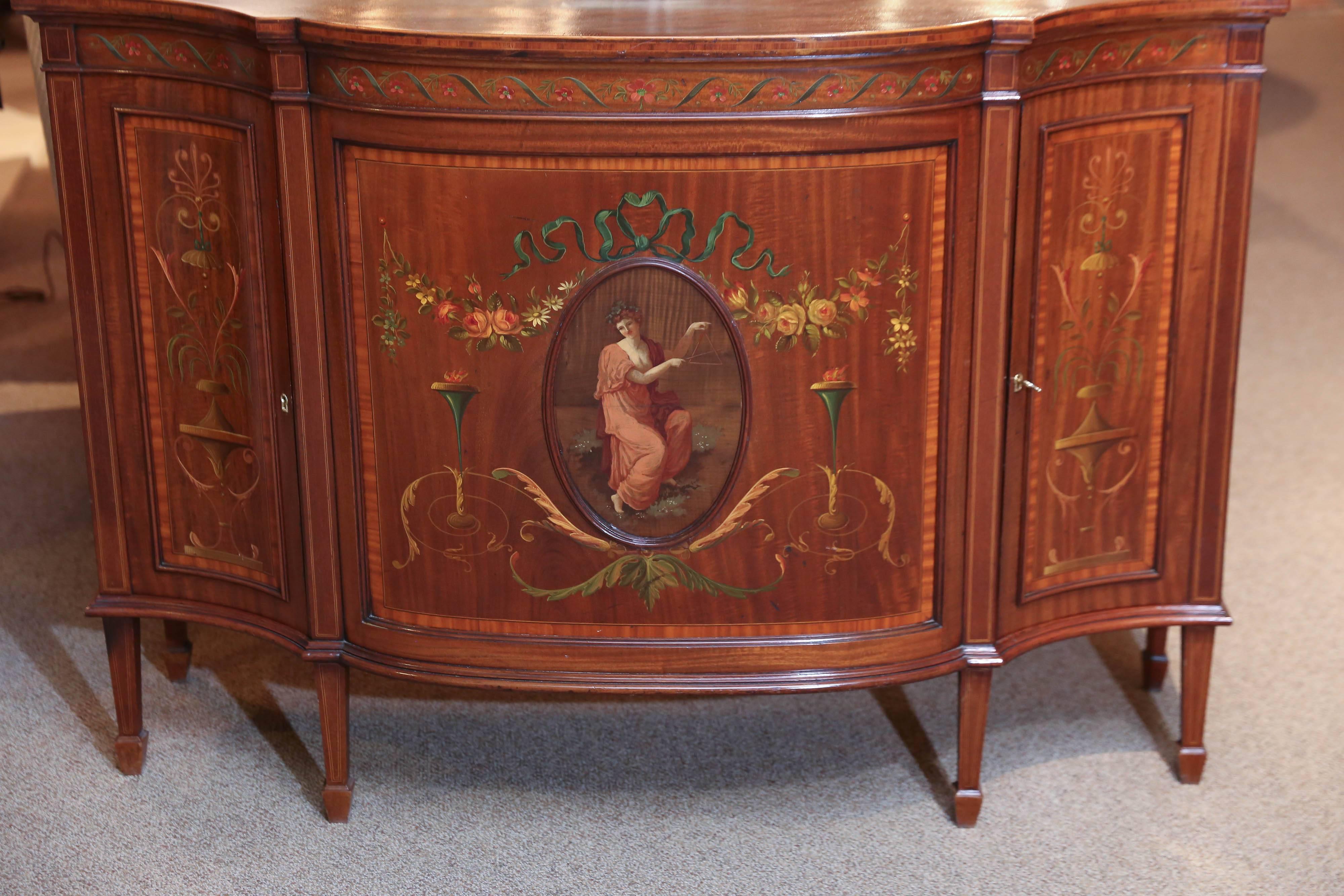 Lovely cabinet hand-painted on three sides. Painted with ribbons and floral
Scrolling patterns in pale pinks and greens. A central oval holds a classical
Woman holding a musical triangle. The shape of the piece gracefully bows
Out in the front.