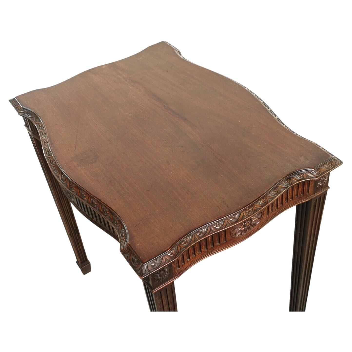 An antique late 19th century Adam style mahogany occasional table, the four sides serpentine form top over a carved frieze, raised on reeded square tapering legs to spade toes.