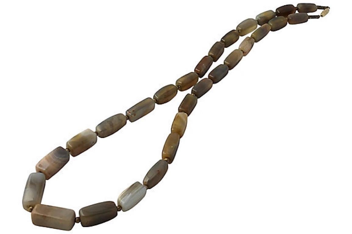 Necklace with graduated banded agate rectangular beads in grays, browns and cream with ribbed gold tone beads and a barrel clasp. Each bead, 1