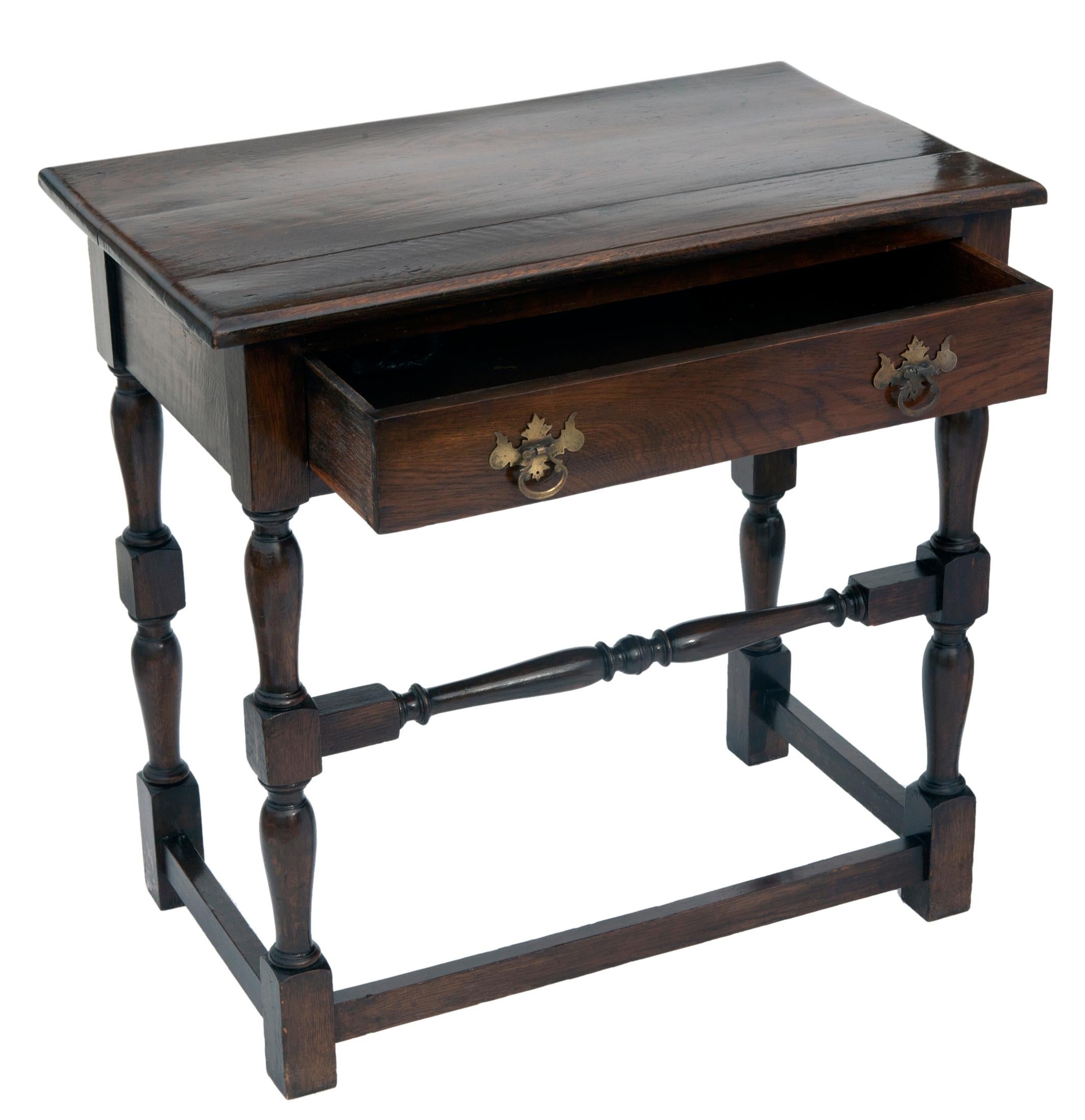 19th century English oak side table with softly curved edge around the top,.
Hand pegged construction. The apron is simple and contains a single drawer over turned bobbin legs, joined by a matching stretcher in the front, and simple stretchers on