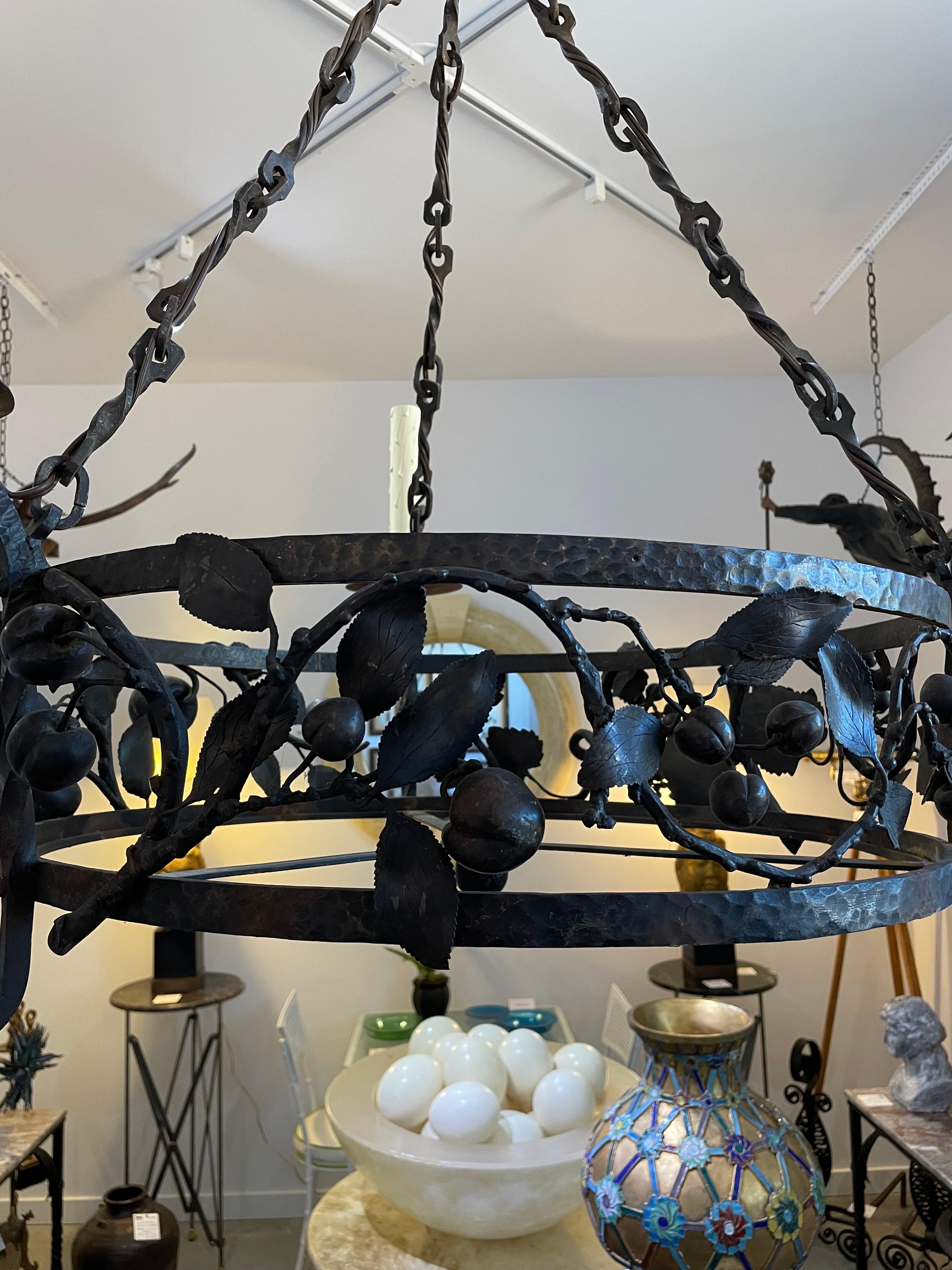 This stylish Spanish Colonial style chandelier was acquired from a Palm Beach home, and the piece is attributed to Addison Mizner.  The piece is detailed with undulating vines with grapes, apples and plums, and with all of this it would make a