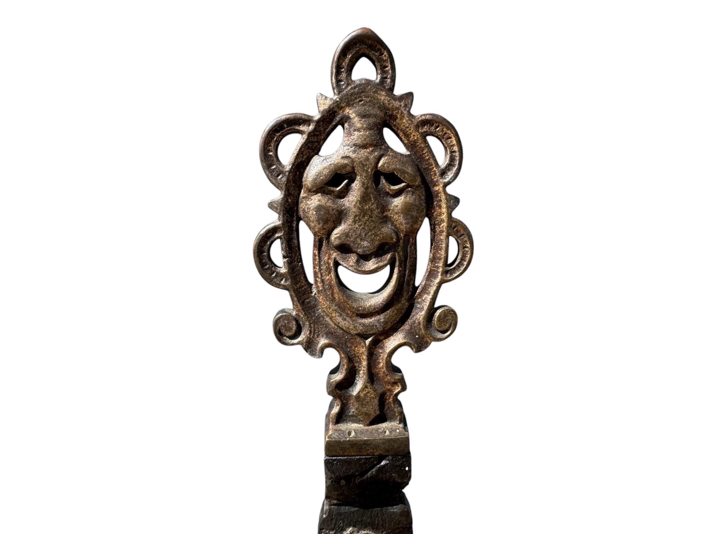 Banc Addison Mizner en bronze et fer forgé, vers 1920, provenant d'une propriété de Palm Beach en Floride. Le dossier à frise est orné de tritons dorés et d'acanthes finement enroulées. Les poteaux sont surmontés d'embouts en forme de masque et le