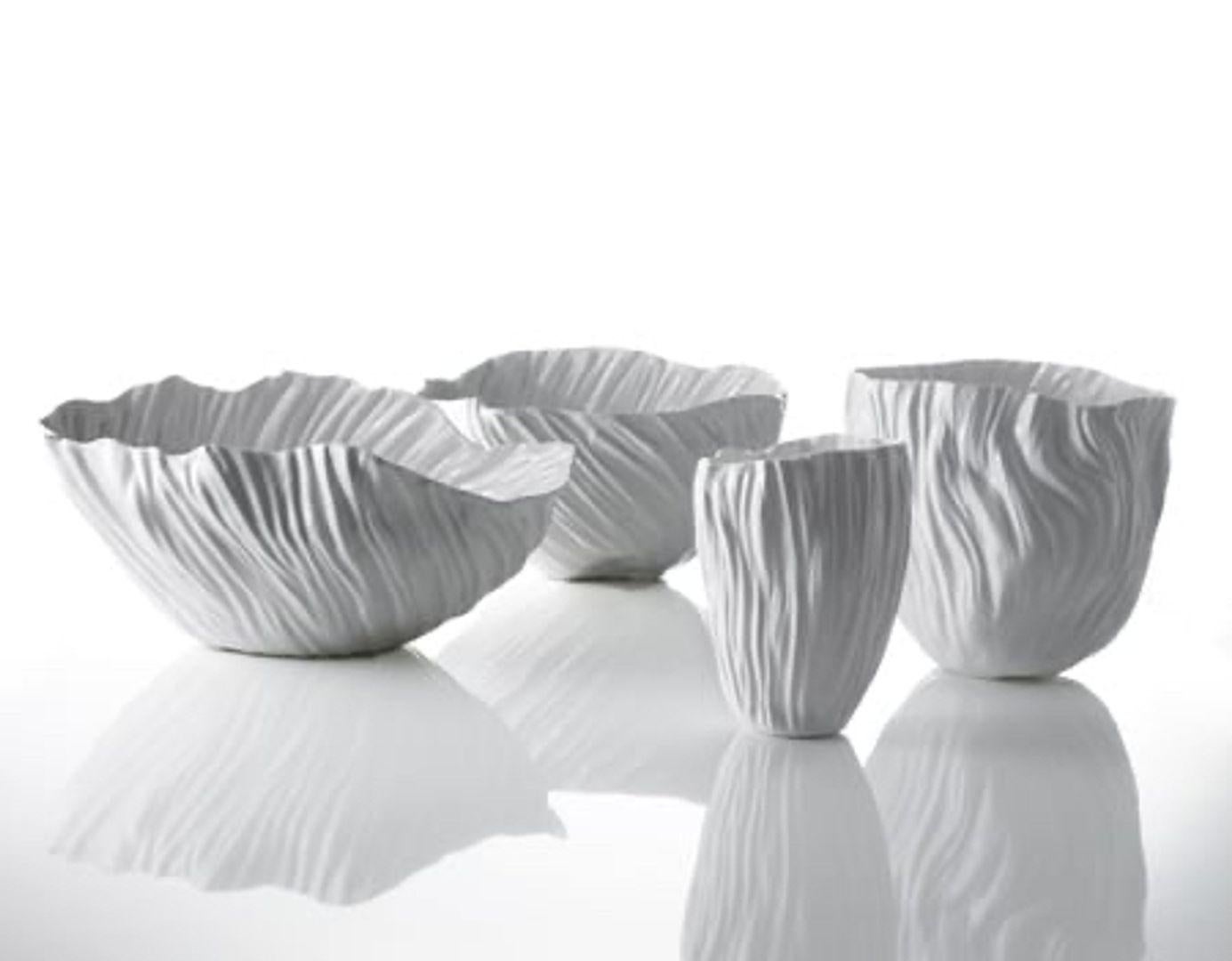 Un service de table en porcelaine blanche Bone China conçu par l'artiste et designer Xie Dong qui a revisité, de manière poétique, le travail de la céramique traditionnelle chinoise.La porcelaine est traitée pour obtenir une épaisseur très fine :