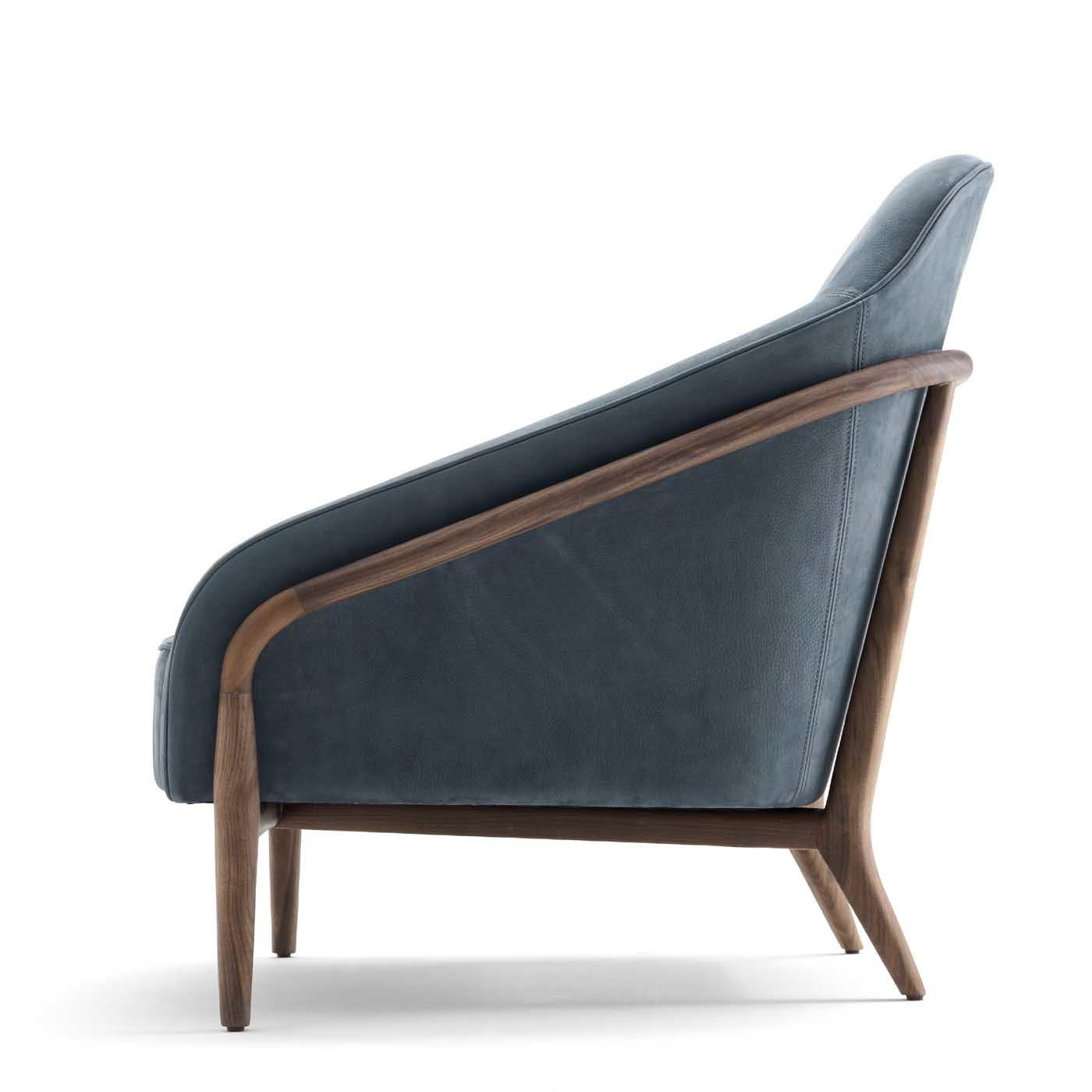This elegant armchair is a celebration of mid-century charm and can be paired with the Doris Sofa for a cohesive visual effect, adding comfortable seating space and elegance to a modern interior. The structure in American walnut features slanted