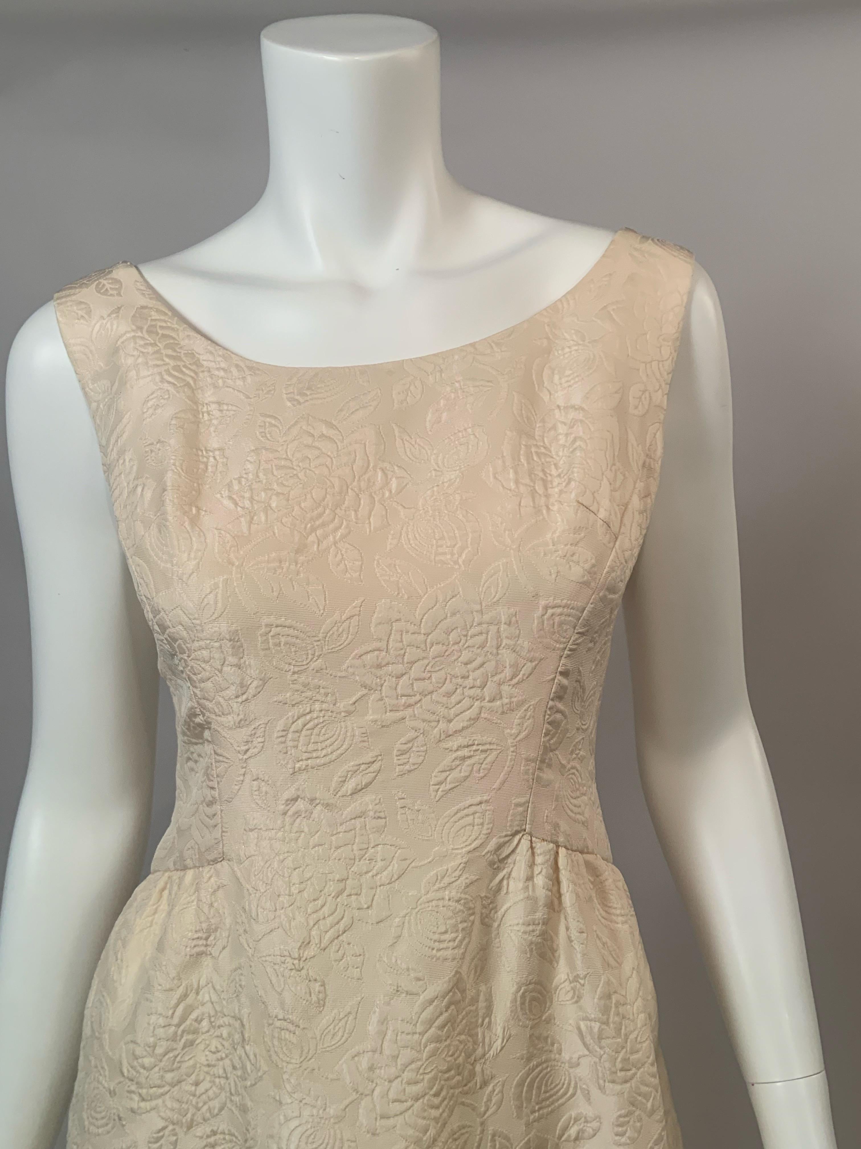 Dieses cremefarbene Seidenmatelasse-Kleid und die Jacke von Adele Simpson für Saks Fifth Ave. haben ein wunderschönes, in den Stoff eingewobenes Blumenmuster.  Es wäre perfekt für eine Braut, eine zweite Hochzeit, die Mutter der Braut oder sogar die