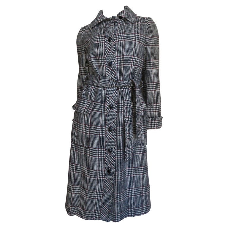 A fabulous coat and skirt set from Adele Simpson in off white, burgundy and black plaid wool. The coat has 2 front flap patch pockets, fold back cuffs with 2 buttons, a back yoke and matching tie belt.  It closes up the front with black buttons. The
