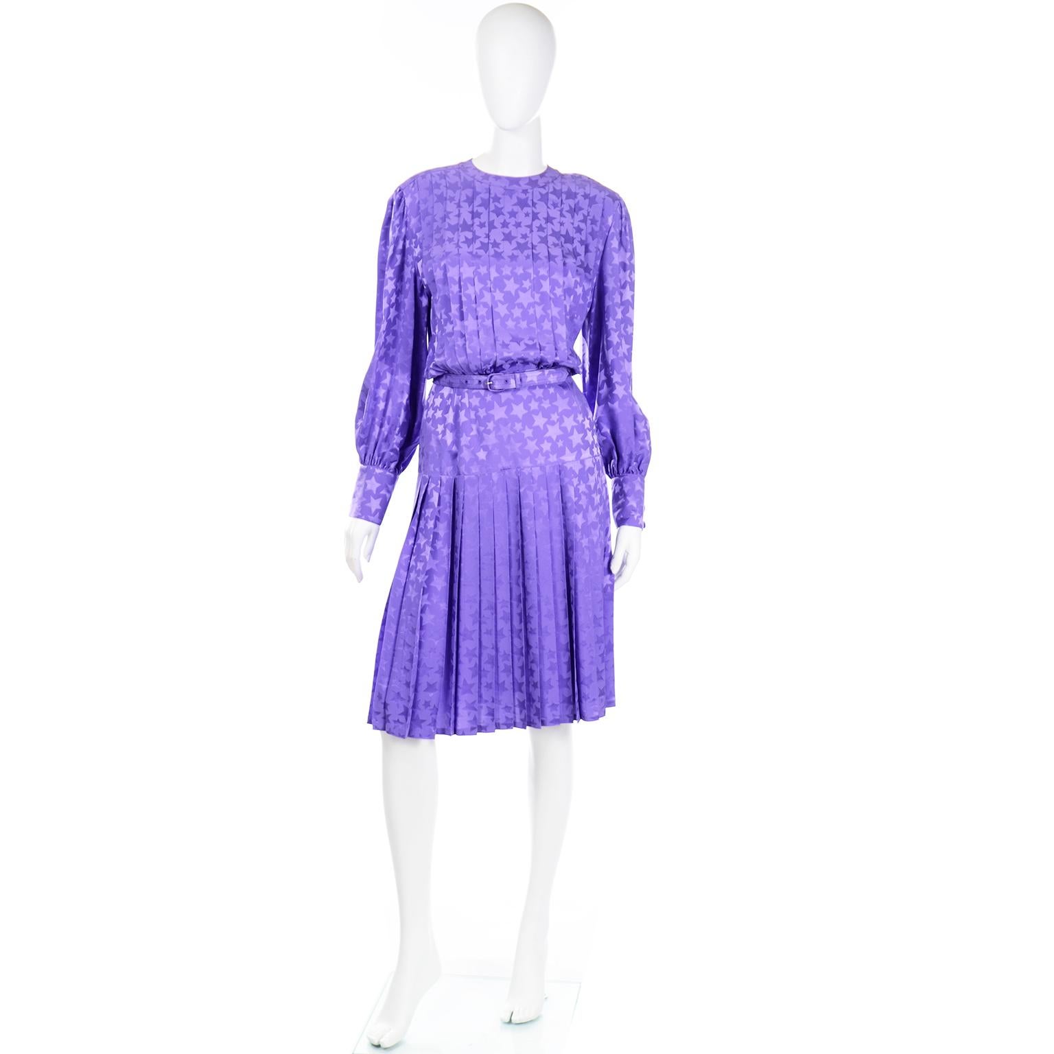 This is a vintage 1980's Adele Simpson purple silk tonal star printed dress. We love vintage Adele Simpson dresses and this one would be perfect to wear out to a nice day event or to a wedding as a guest.  There is a pretty pleated skirt and a wide,