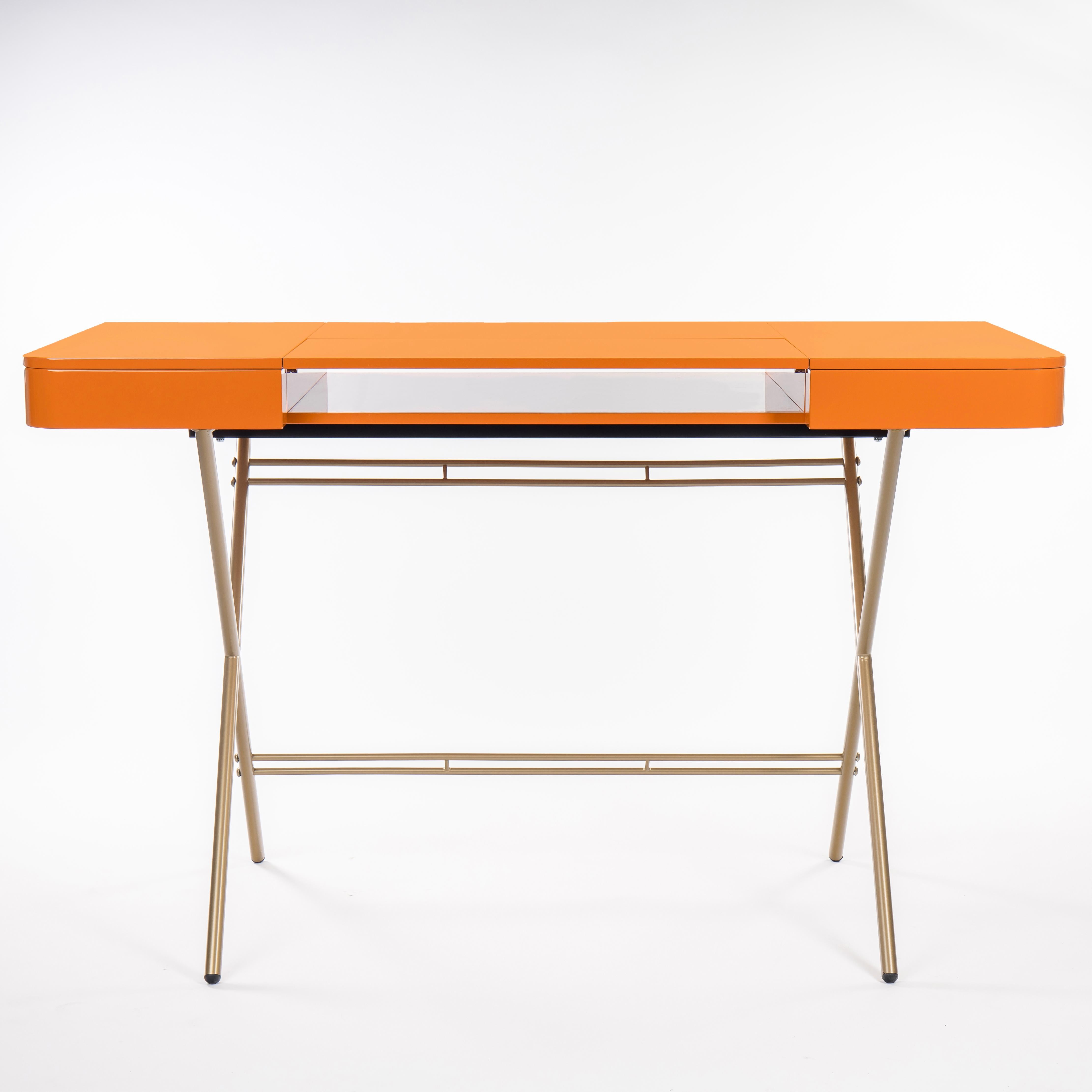 Der Schreibtisch Cosimo wurde 2017 von dem Architekten Marco Zanuso Jr. für die französische Luxusmöbelmarke Adentro Paris entworfen. Die mittlere Platte des Schreibtisches lässt sich zurückklappen, um ein verstecktes Regal darunter freizugeben, und