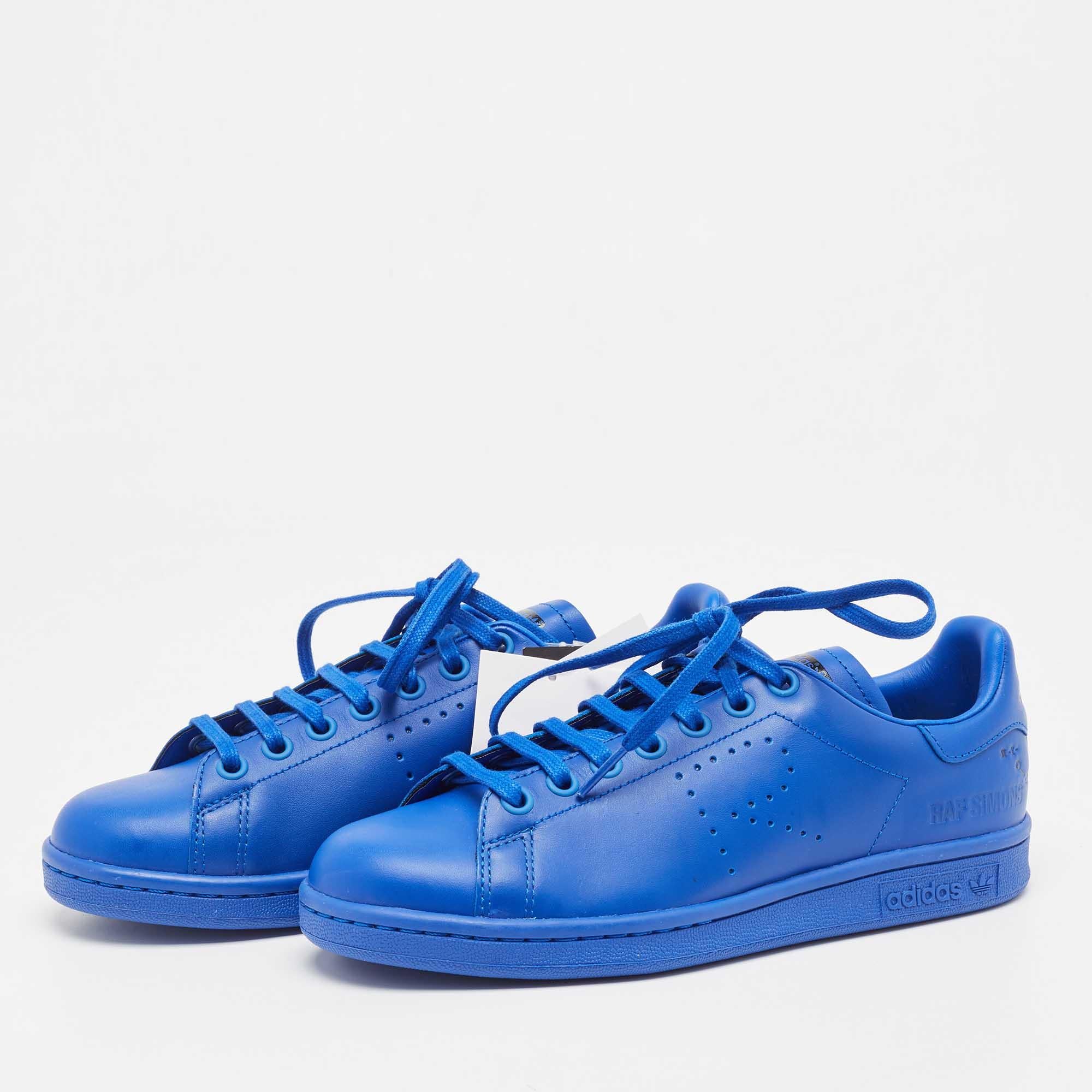 Step into contemporary elegance with the Adidas By Raf Simons Stan Smith sneakers. Crafted from supple leather, these shoes boast a vibrant blue hue that commands attention. Raf Simons' signature touch elevates the iconic Stan Smith silhouette,