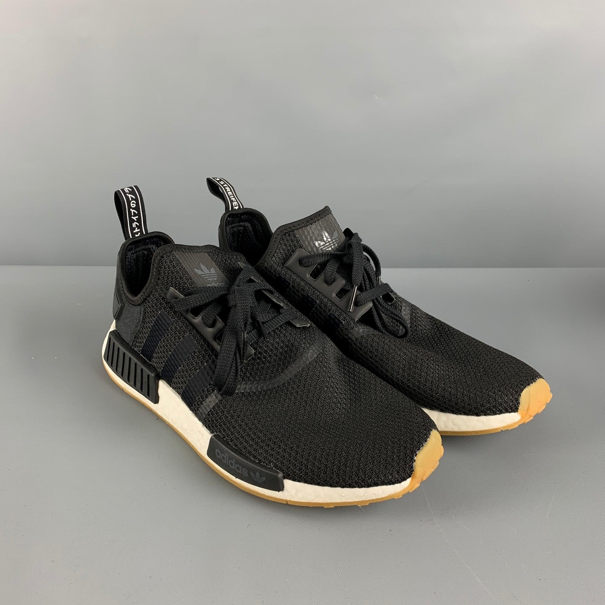 ADIDAS NMD_R1 Boost sneakers comes in a black woven nylon featuring the iconic striped design, rubber details, and a lace up closure.Good Pre-Owned Condition. 

Marked:   13Outsole: 13 inches  x 4 inches 
  
  
 
Reference: 126426
Category: