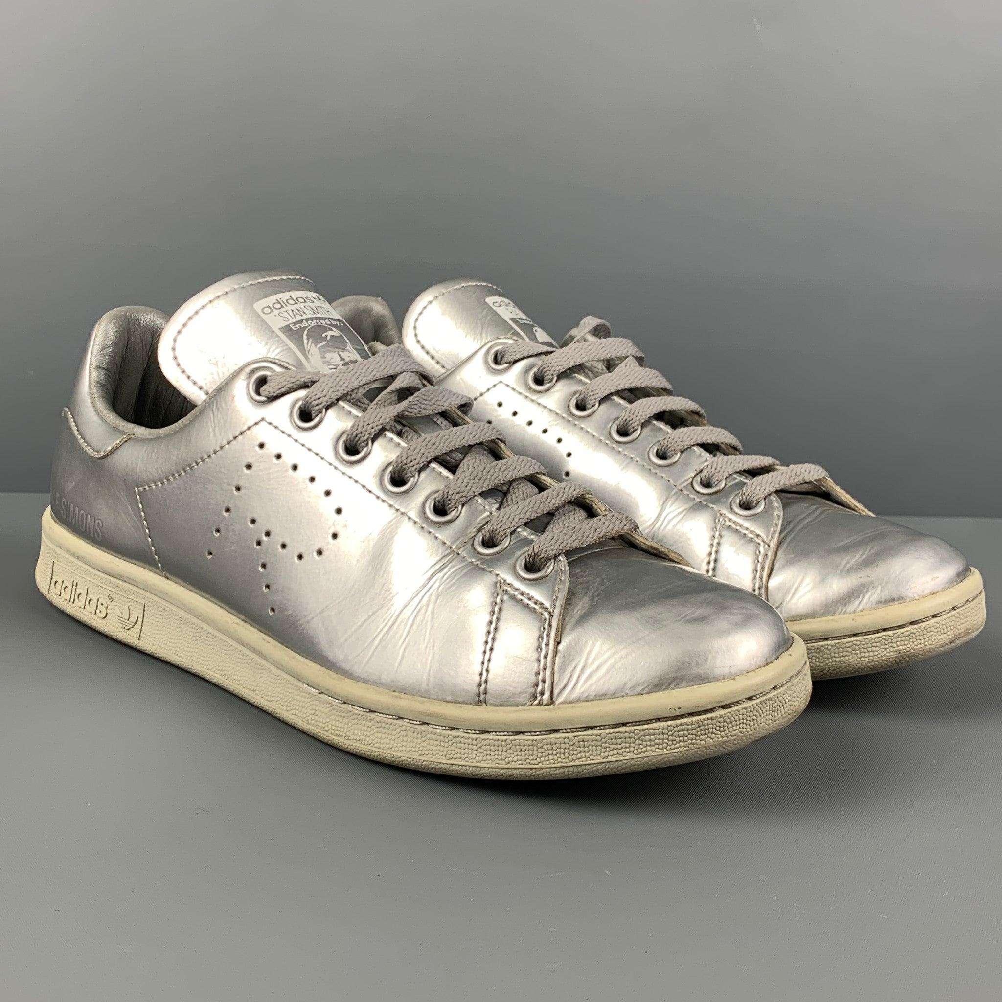ADIDAS x RAF SIMONS sneakers comes in a silver metallic leather featuring a low top style, perforated 'R' detail, and a lace up closure.
 Good
 Pre-Owned Condition. Light wear. As-is.  
 

 Marked:  8.5Outsole: 
 11.25 inches x 4 inches 
  
  
  
