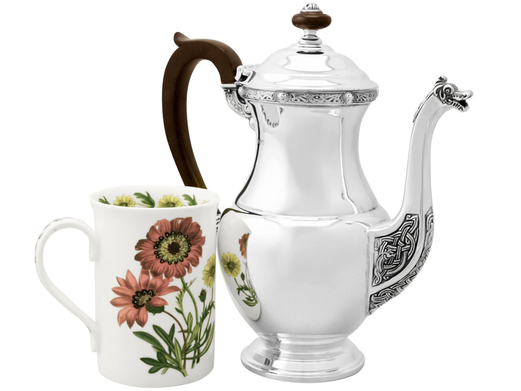 A fine and impressive vintage Elizabeth II English sterling silver coffee pot, an addition to our silver teaware collection.

This fine vintage Elizabeth II sterling silver coffee pot has a plain baluster shaped form onto a circular domed