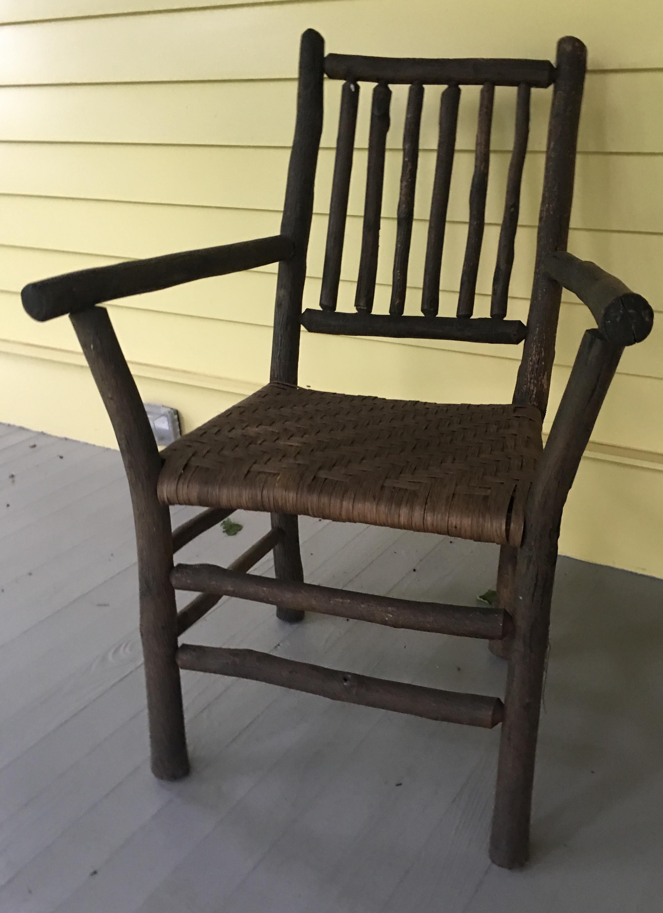 This Adirondack arm chair is great looking, solid construction, and a lovely addition to rustic settings, porch or patio. The woven seat is original and in good condition.  