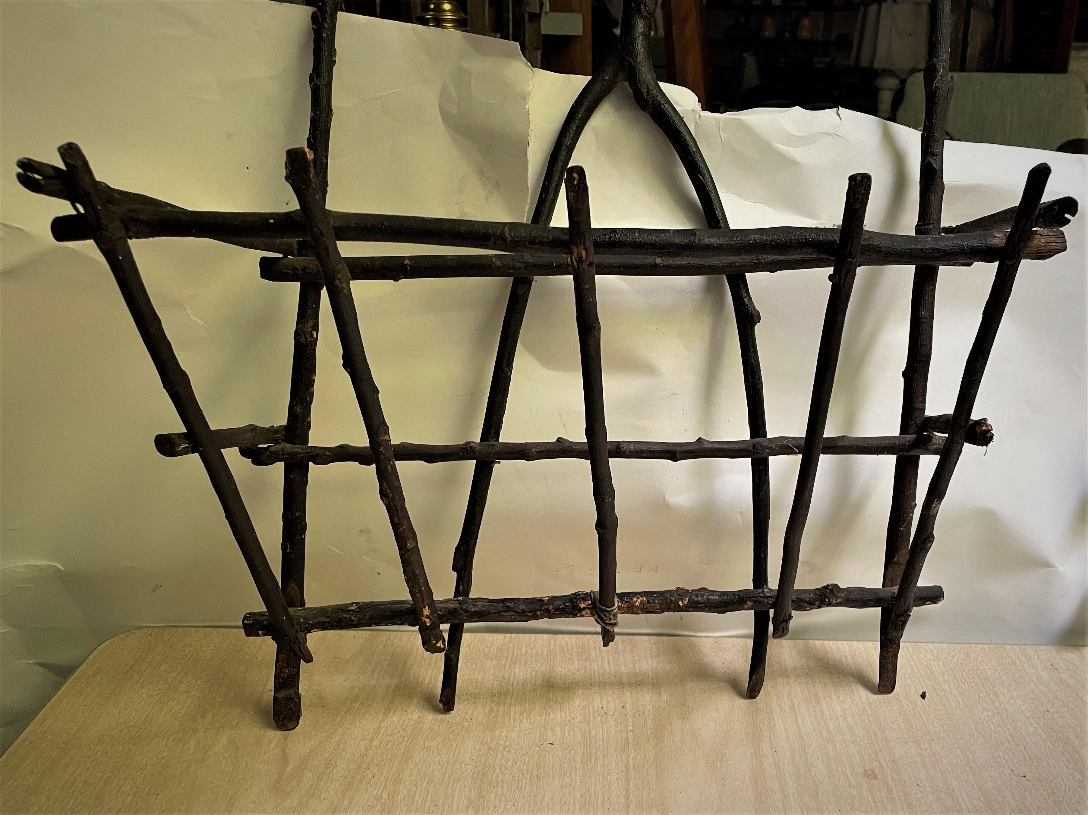 This is a great Adirondack style artisan made wall mount basket type holder. with a wishbone shaped twig in the center back which has been finished with a dark stain. It would be great with some Spanish moss and dried flower or other decorative