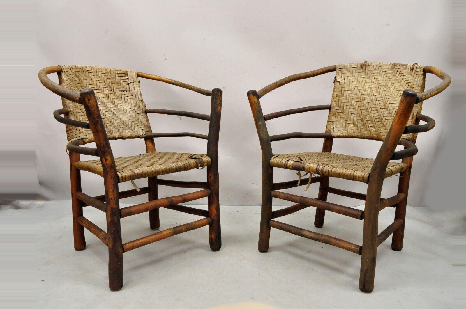 Vintage Adirondack Old Hickory Style Tree Branch wood Frame Rattan lounge chairs - a Pair. Item features woven rattan back and seats, nice wide frames, half round form, solid wood frames, distressed finish, very nice vintage pair, great to restore.
