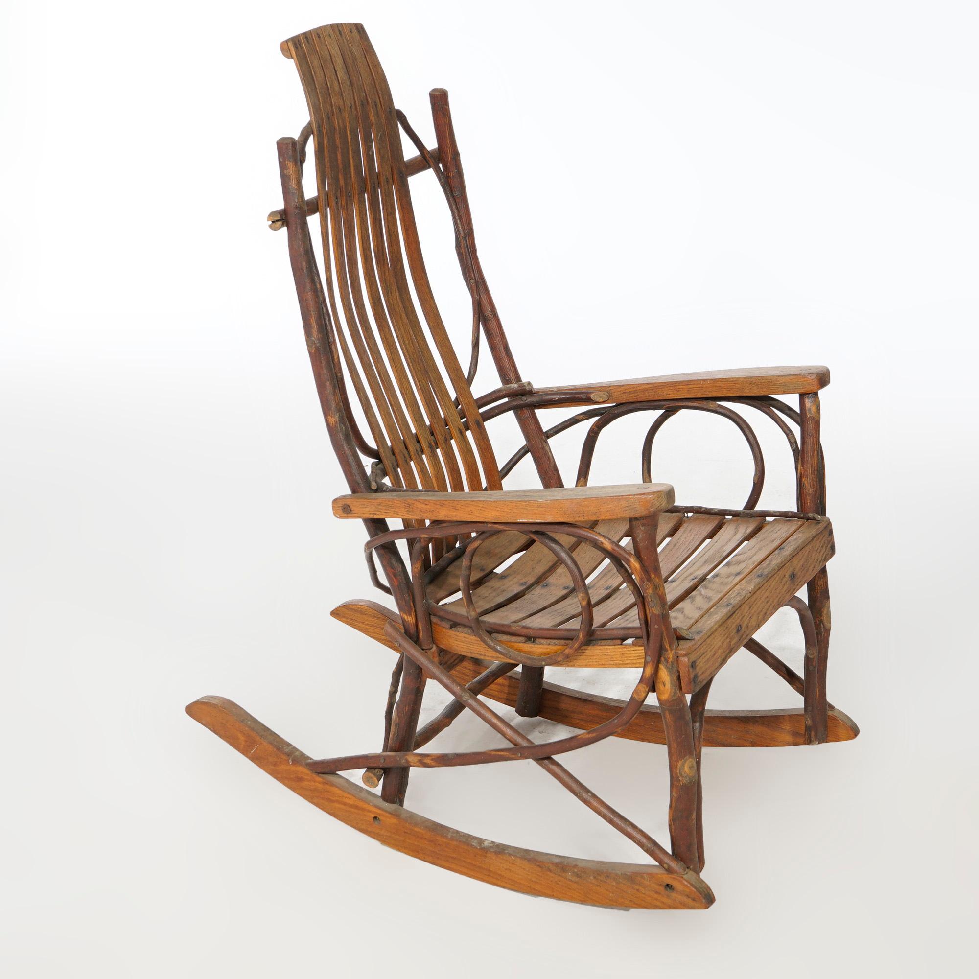 An Adirondack style rocking chair in the manner of Old Hickory offers branch form frame with slat back and seat, c1950

Measures- 36.75''H x 22.25''W x 26.5''D