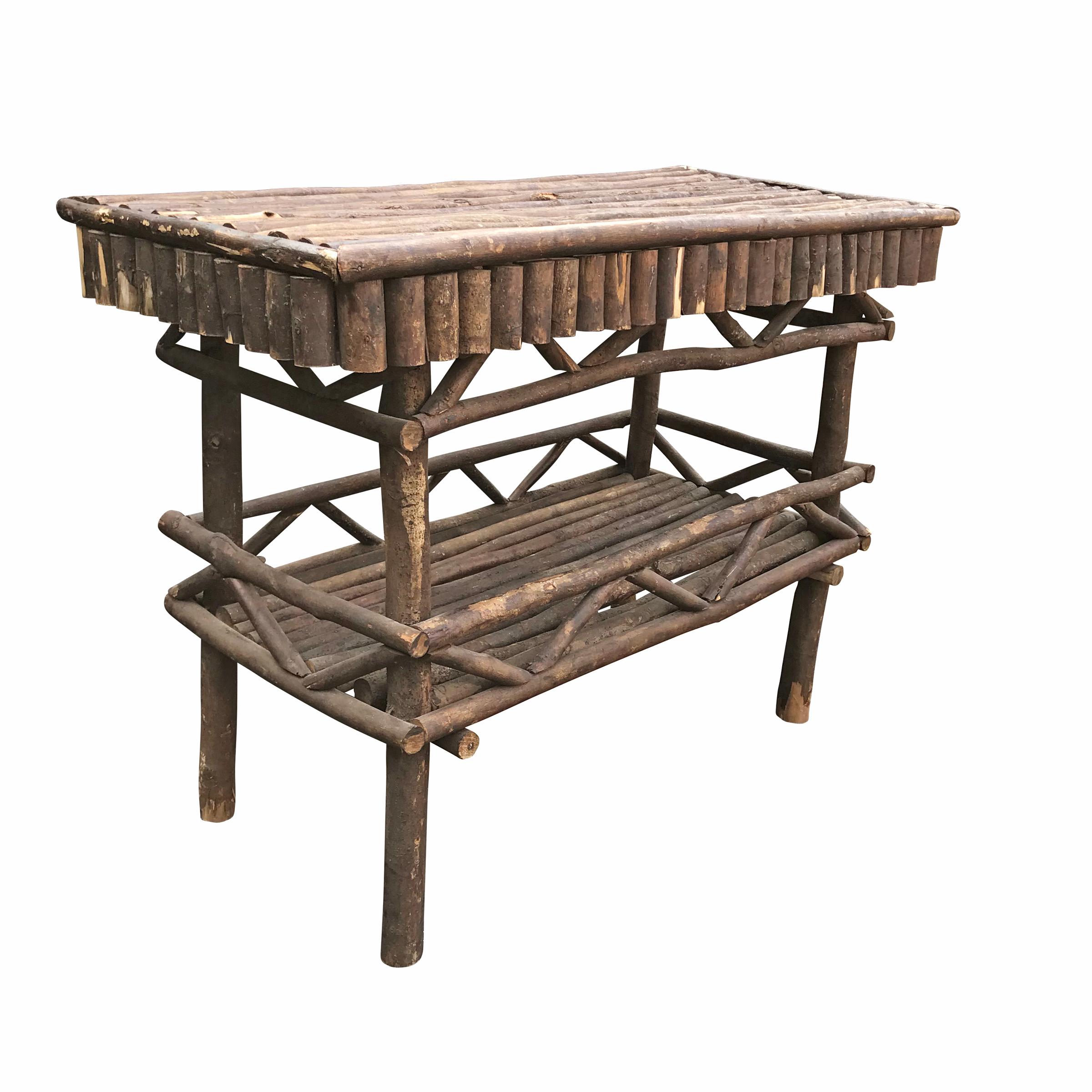 A whimsical early 20th century American Adirondack style console table composed of cut branches arranged side by side and on angles to create the apron and lower shelf. The Adirondack style drew upon Swiss chalet architecture and was made popular by