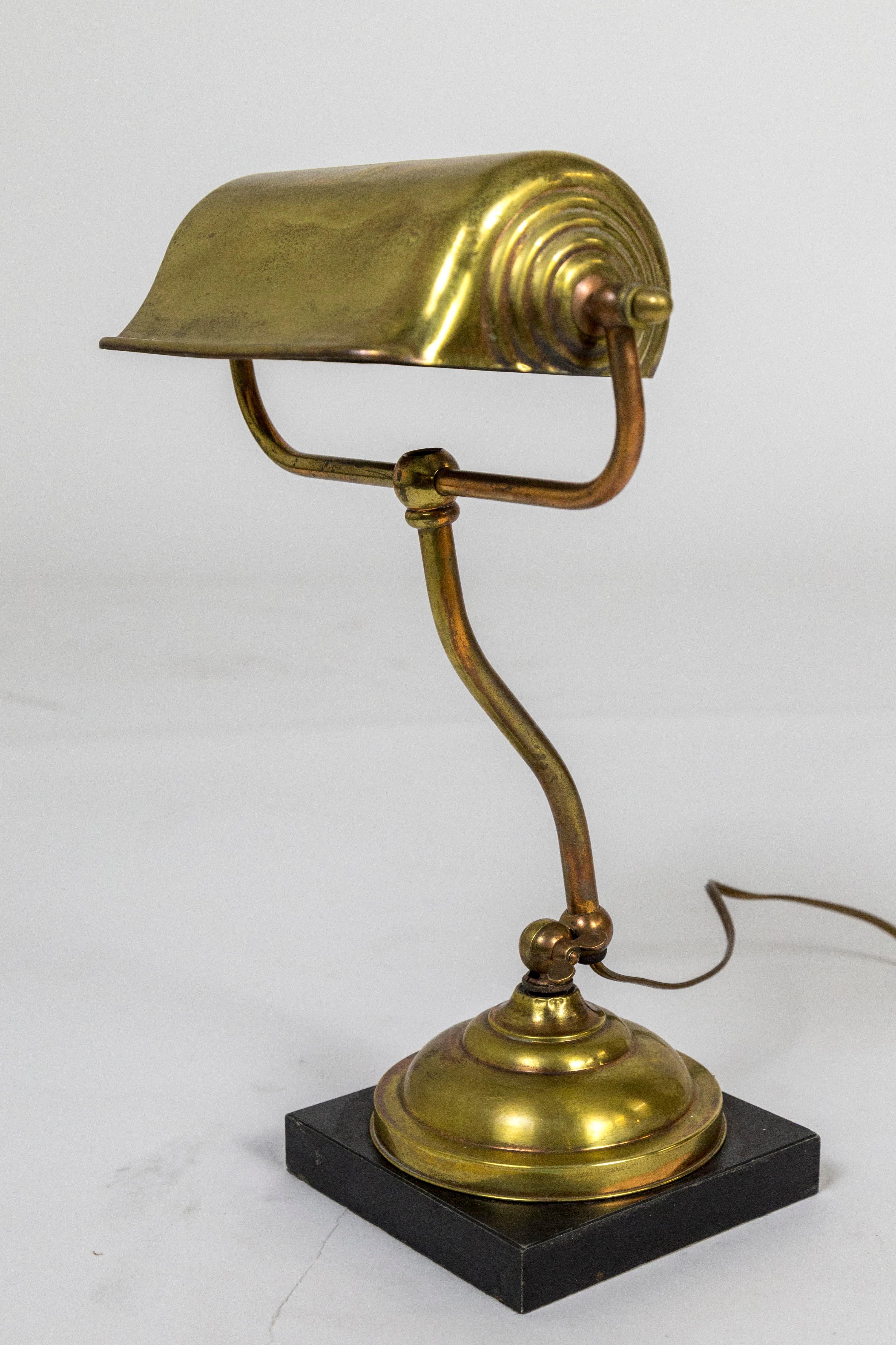 American brass and copper desk lamp with a curved stem and black, square marble base. The shade has circular details that give it a snail shape from the side, 1940s. Adjustable. One medium base socket, newly wired. 6.5” square base, shade 9”x 2.5” x