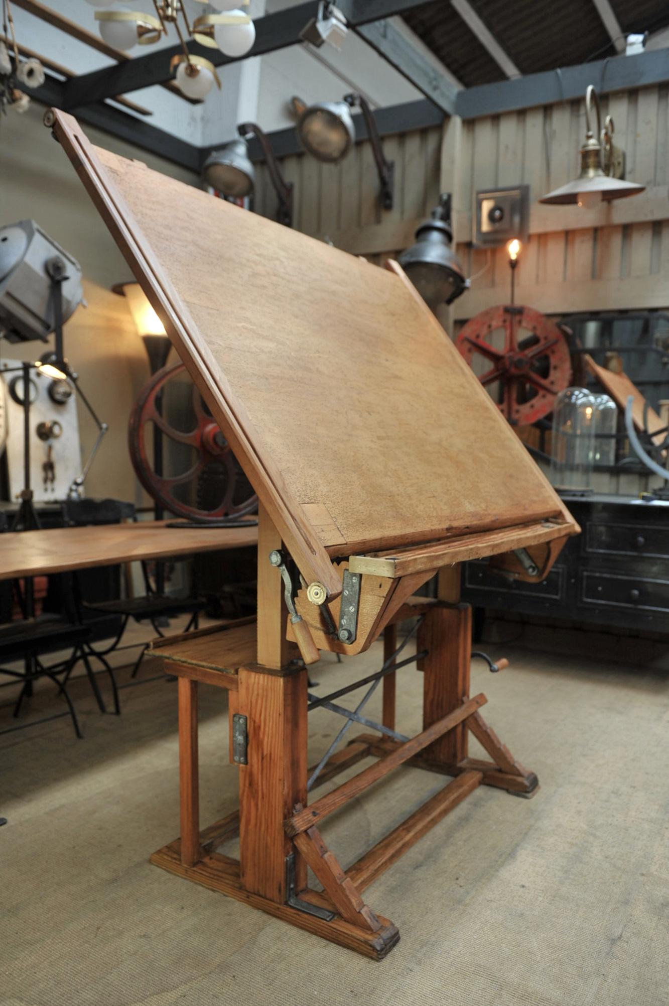 French pine and beechwood architect's drafting table, adjustable in height with crank handle and horizontal with metal pole by foot, circa 1920.
Top part is 149 x 106 cm base 112 x 70 cm, height when almost horizontal for desk position: 89 to 106