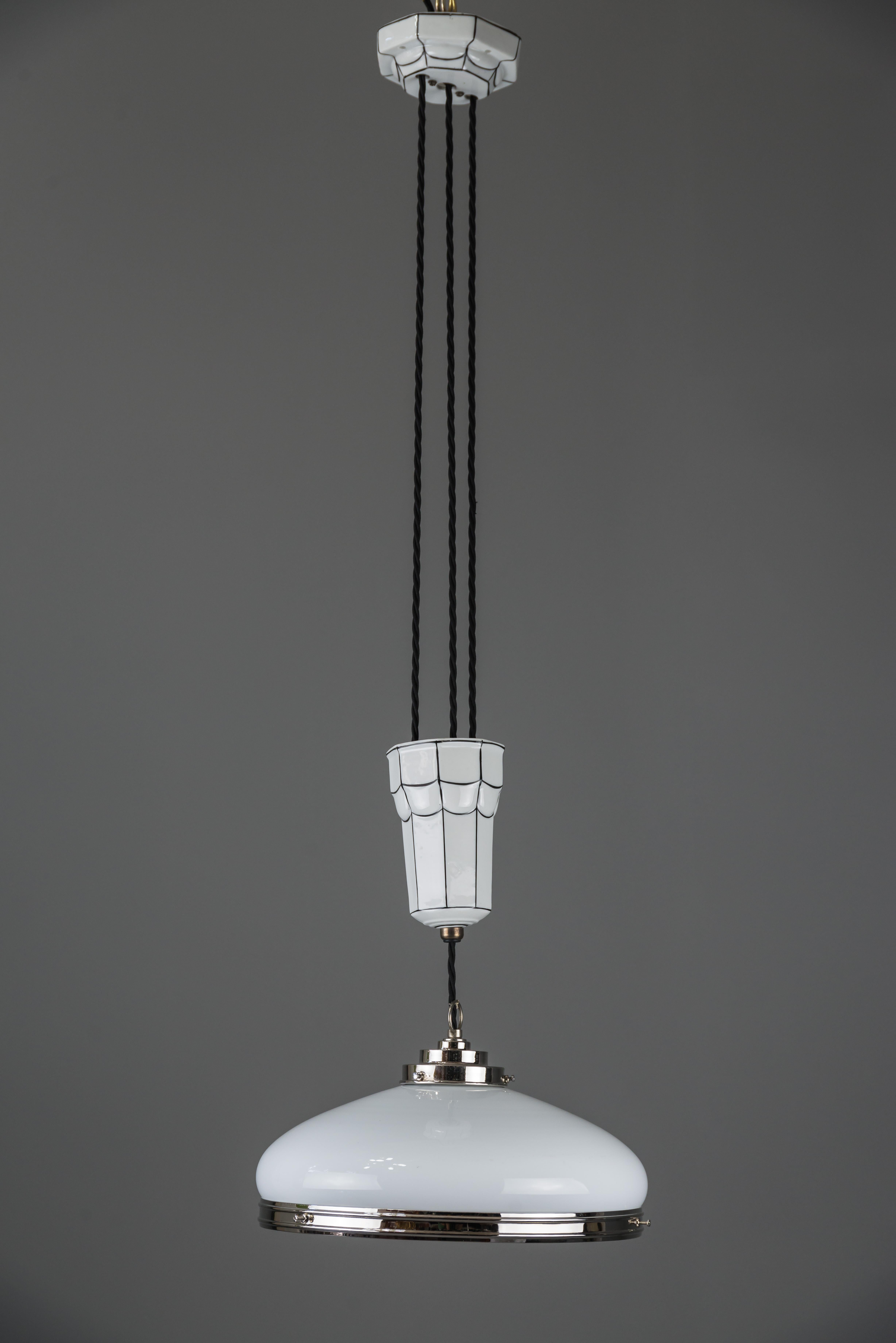 Adjustable Art Deco chandelier 1920s by Bauhaus
Porcelain and glass
Nickel-plated
Original shade
The high is adjustable from 102cm to 190cm.
   