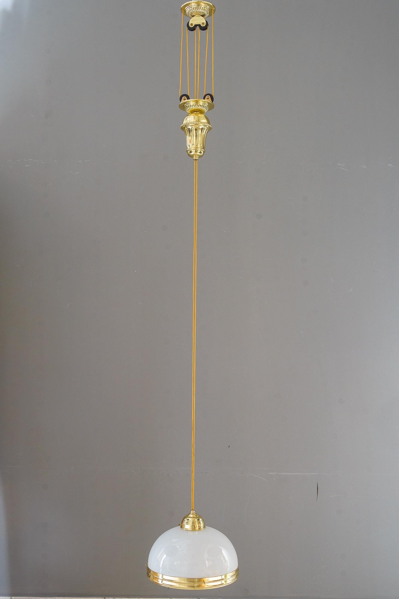 Pendentif art déco réglable vienne des années 1920 
H : de 98cm à 197cm
Position intermédiaire : 126cm
Laiton poli et émaillé au four
Abat-jour original en verre opale
