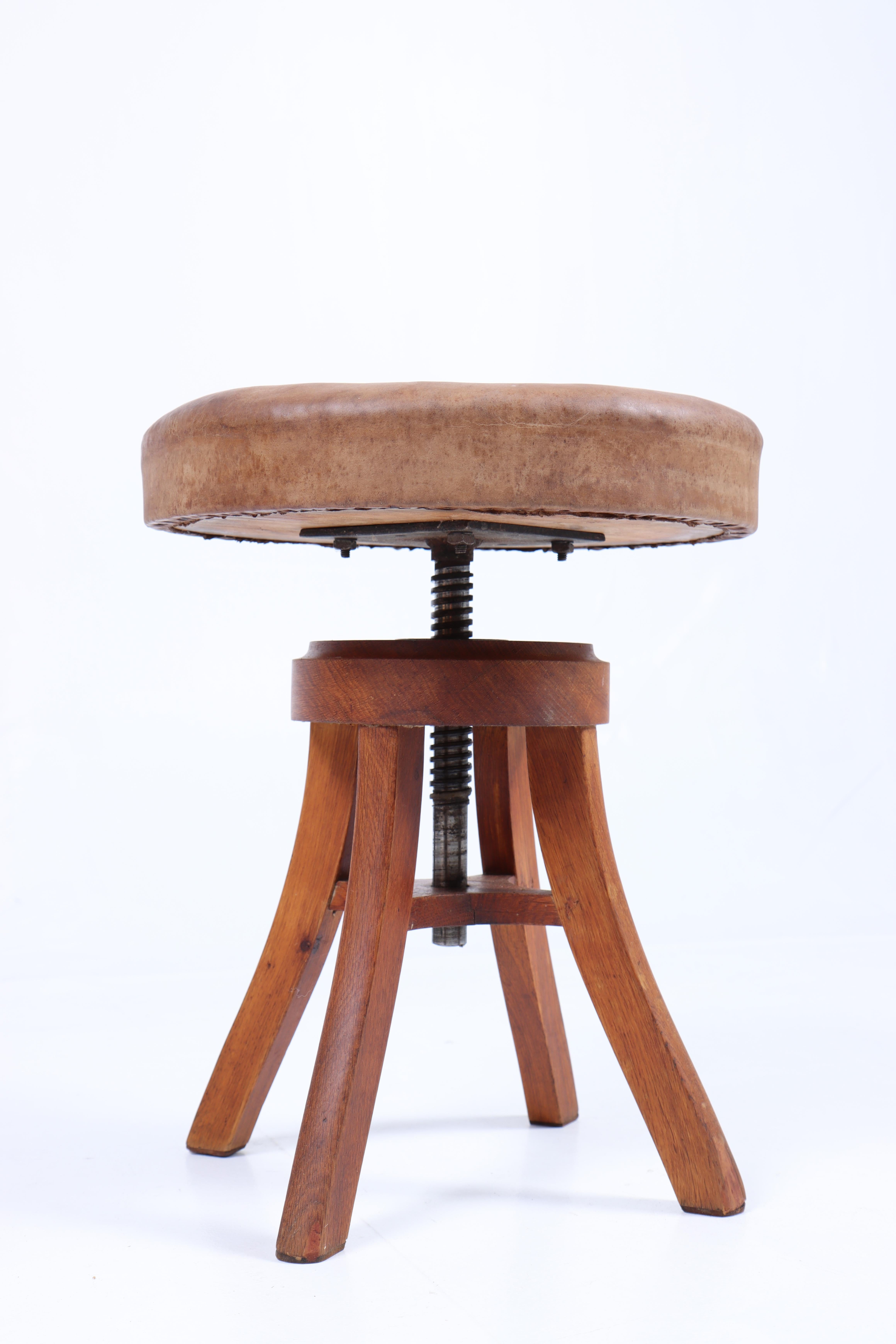 Artist stool in oak and patinated leather, designed and made in Denmark. Original condition.