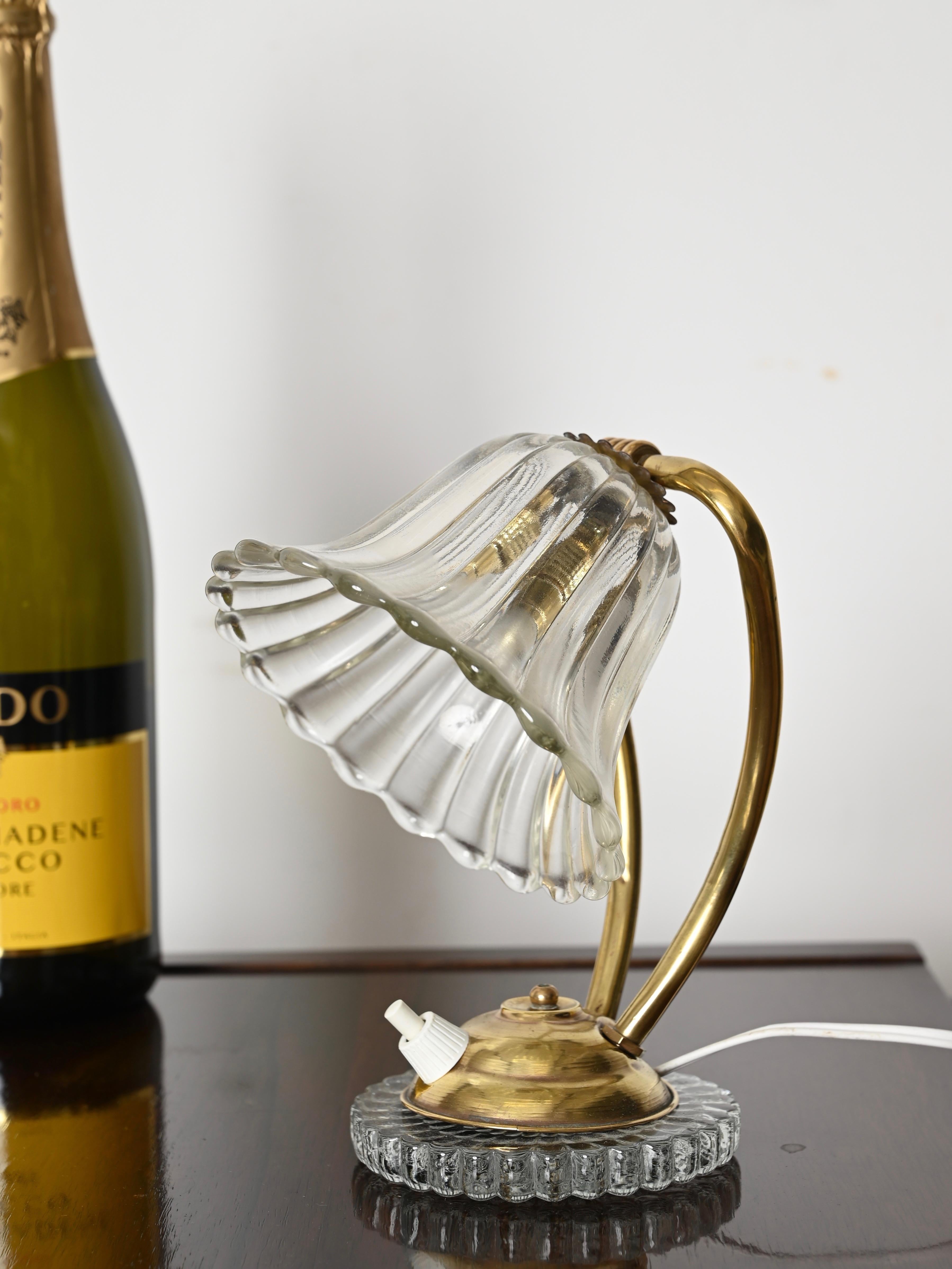 Stunning adjustable table lamp in mouth-blown Murano glass and brass. This incredibly stylish and unique lamp in the shape of a bell flower was designed by Ercole Barovier and produced in Italy during the 1940s. 

In fabulous condition, with no