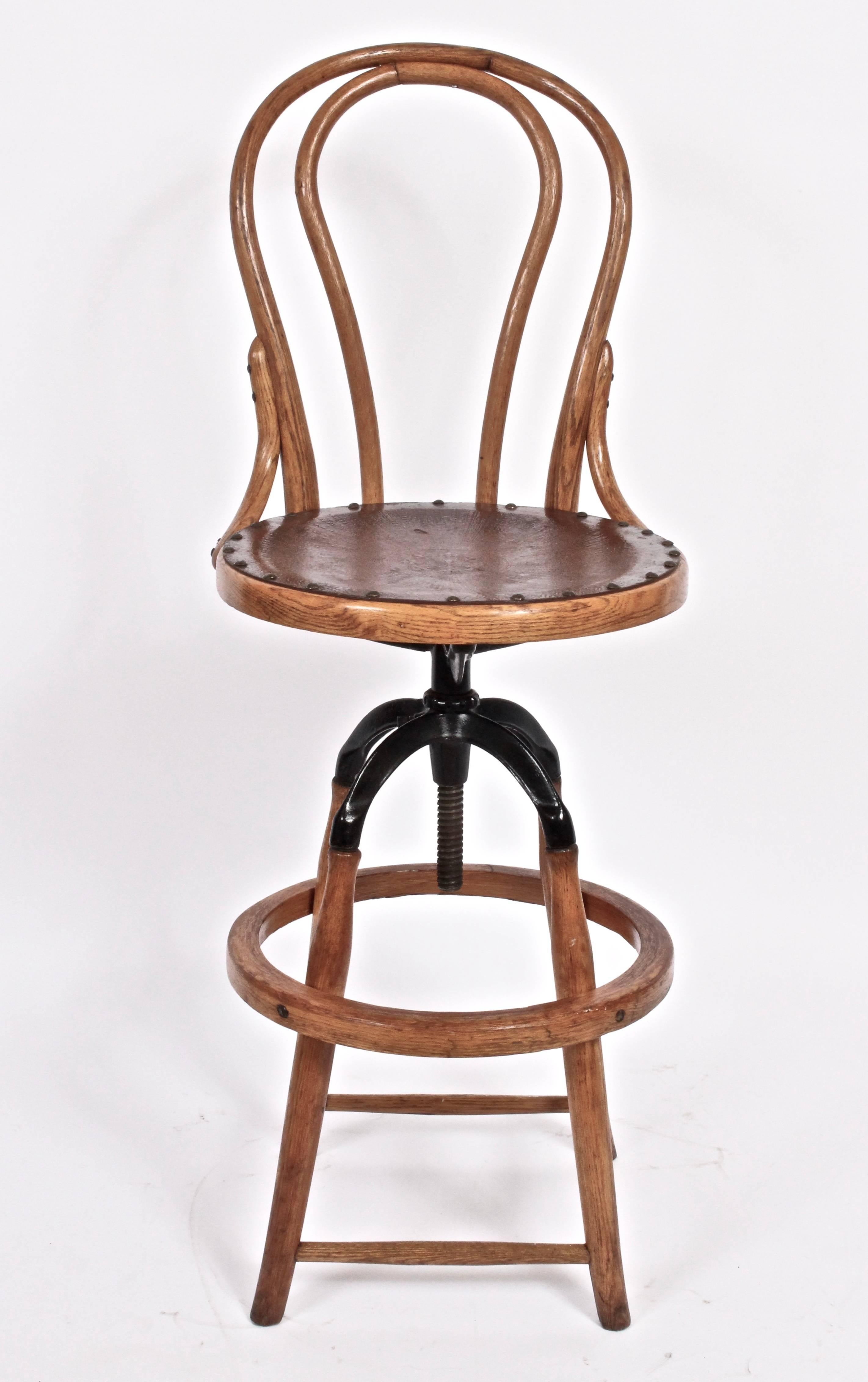 Turn of the Century Architects Oak and Black enameled Iron swivel Stool with Oak heel ring. Oak tower base. Vintage Brown leather seat. Adjustable height. Seat height up to 31H (Seat height range 27-31). Versatile. Office. Counter. Bar. Kitchen.