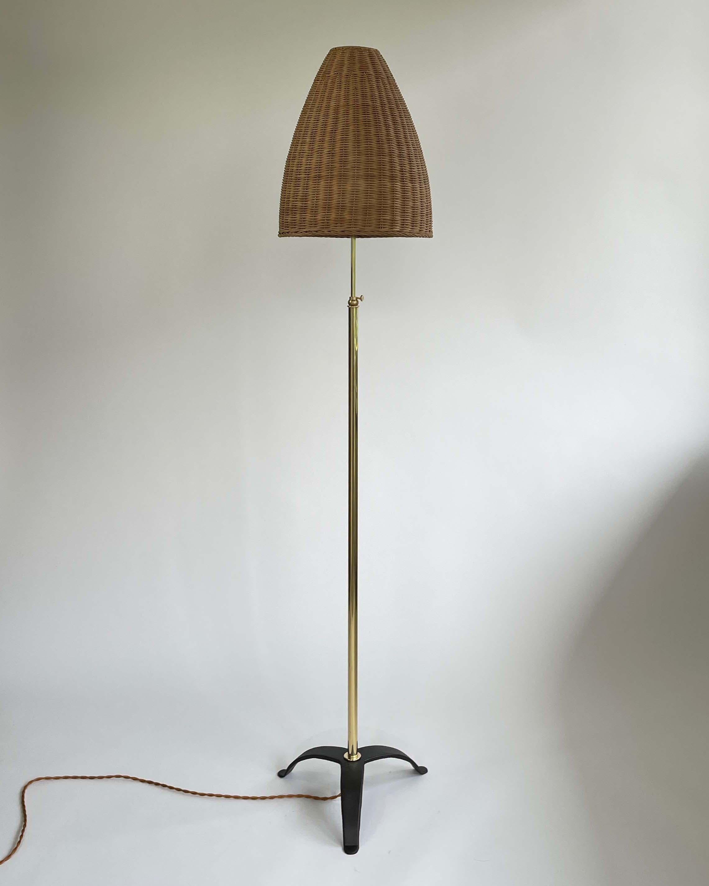 This unusual floor lamp was designed and manufactured in Austria in the 1960s. It features a beehive shaped rattan lampshade and a tripod brass base. 

The light is adjustable from 55.1