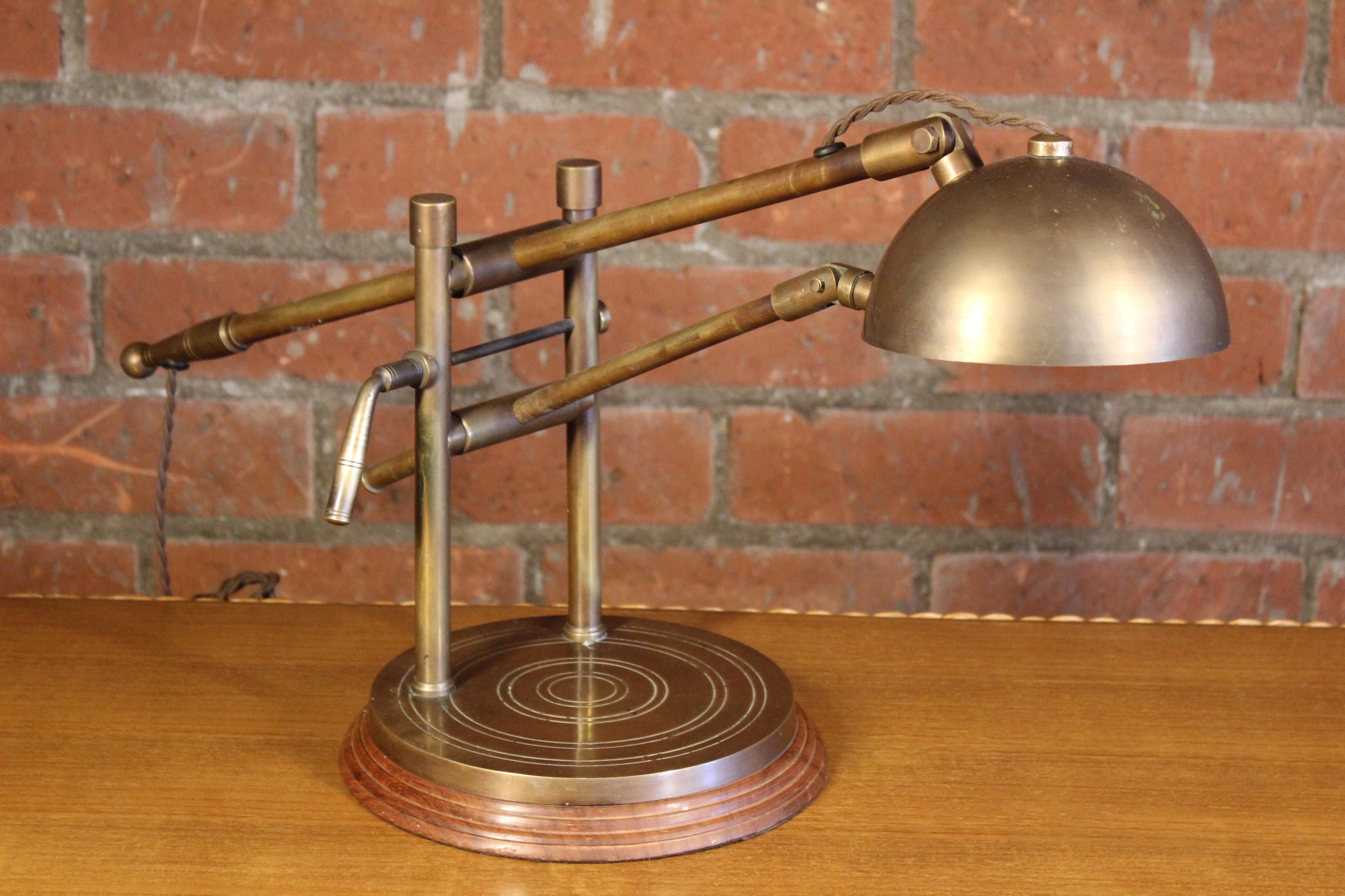 A vintage brass desk lamp from France, 1940s. Newly rewired for U.S standards. Sits on a beautiful solid wood base with nice carved details. Brass shows some patina which only adds to the beauty of this piece. 

 