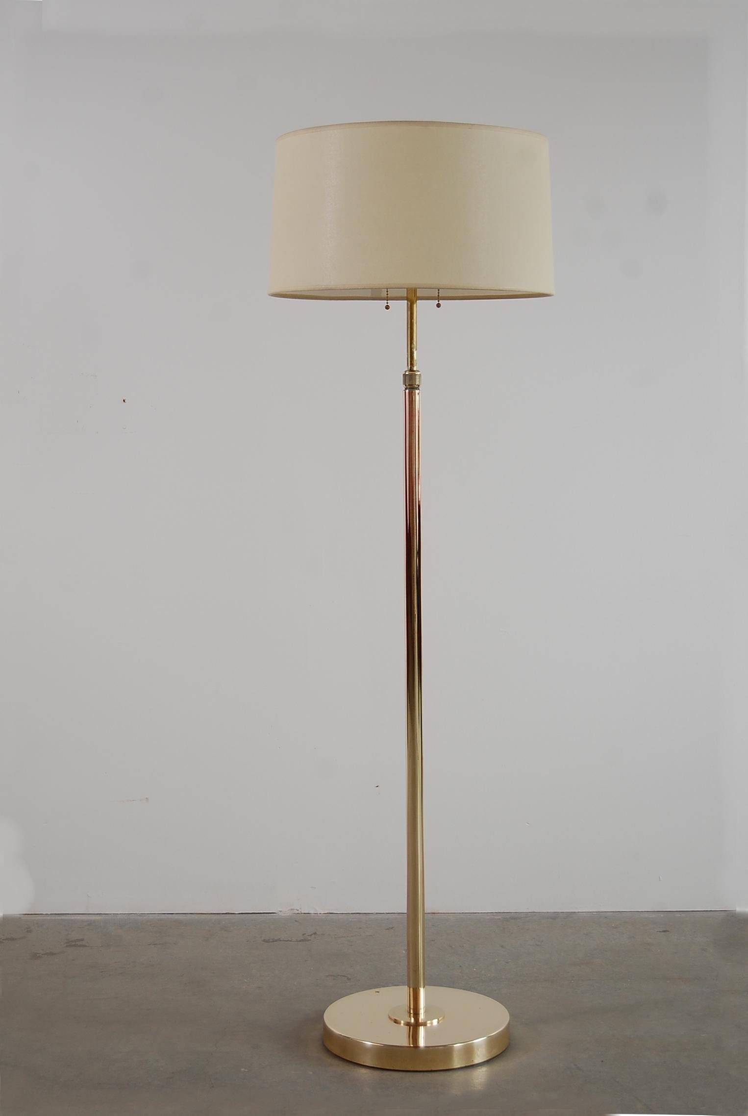 Adjustable brass floor lamp by Nessen Studios of New York, circa 1939. Adjusts from floor lamp height (65