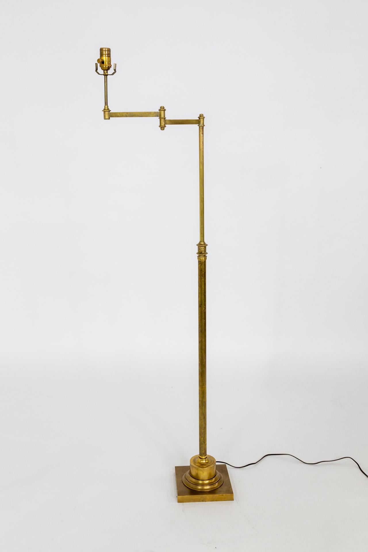 A heavy, solid brass floor lamp with telescoping height adjustment and extendable arm.  The square base has a large cylindrical cap; lovely joints and proportions.  A classy, finely crafted, versatile lamp.  Great condition and newly rewired with a
