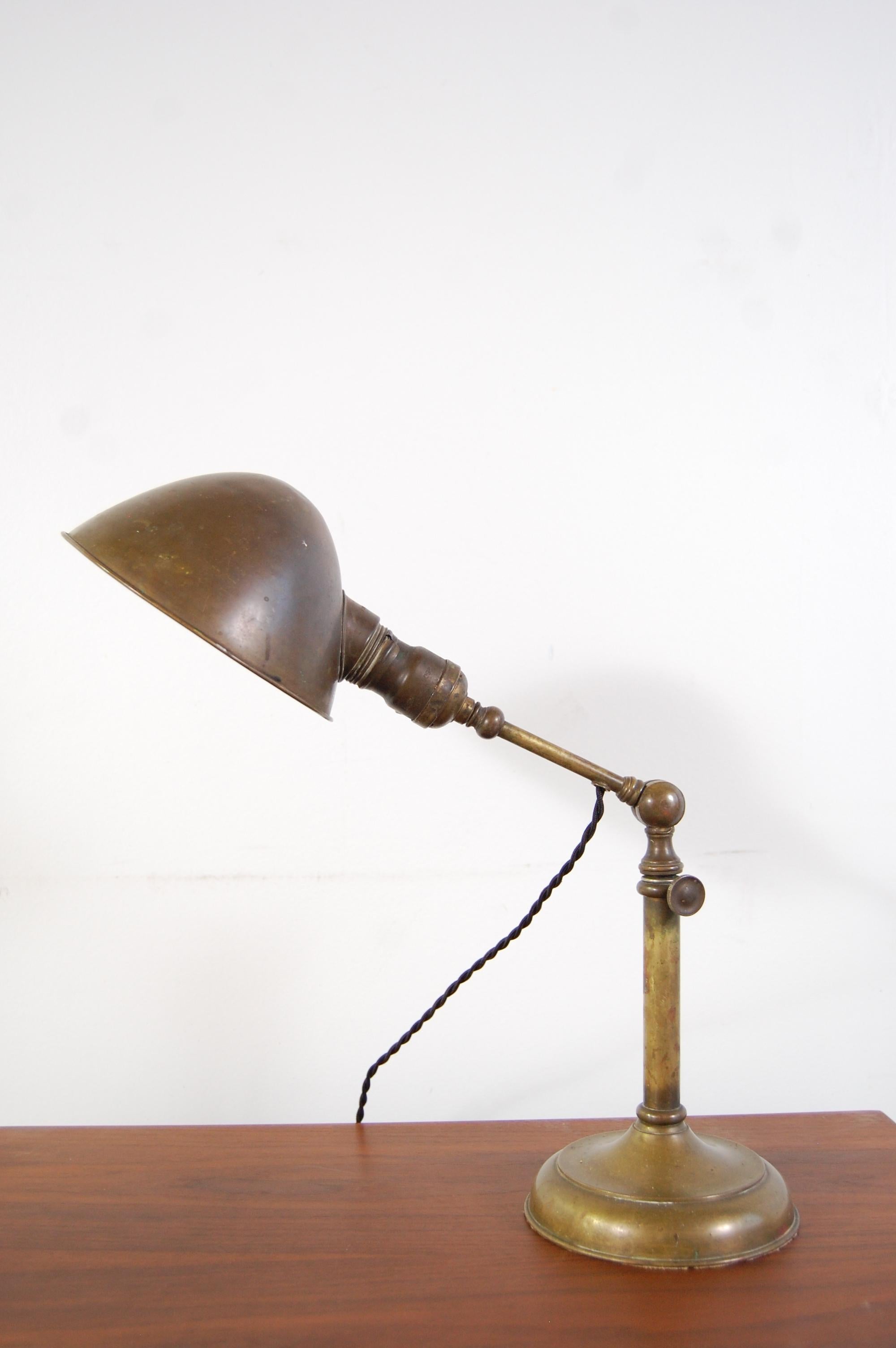 Adjustable brass Jeweler's lamp or desk lamp, circa 1900s. Lamp has been completely re-wired for safety, as all vintage lighting should be. Lamp is approximately 17