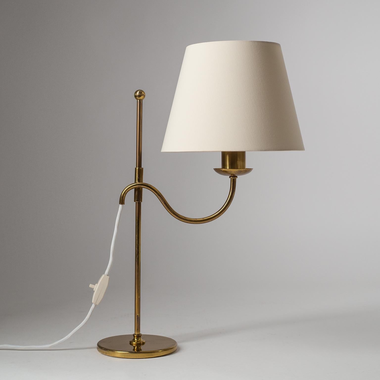 Fine Austrian brass table light from the 1940s, attributed to J.T. Kalmar. A simple, yet very effective, sliding mechanism allows the height of the shade to be to adjusted effortlessly as well as rotated 360º. Very nice condition with patina on the