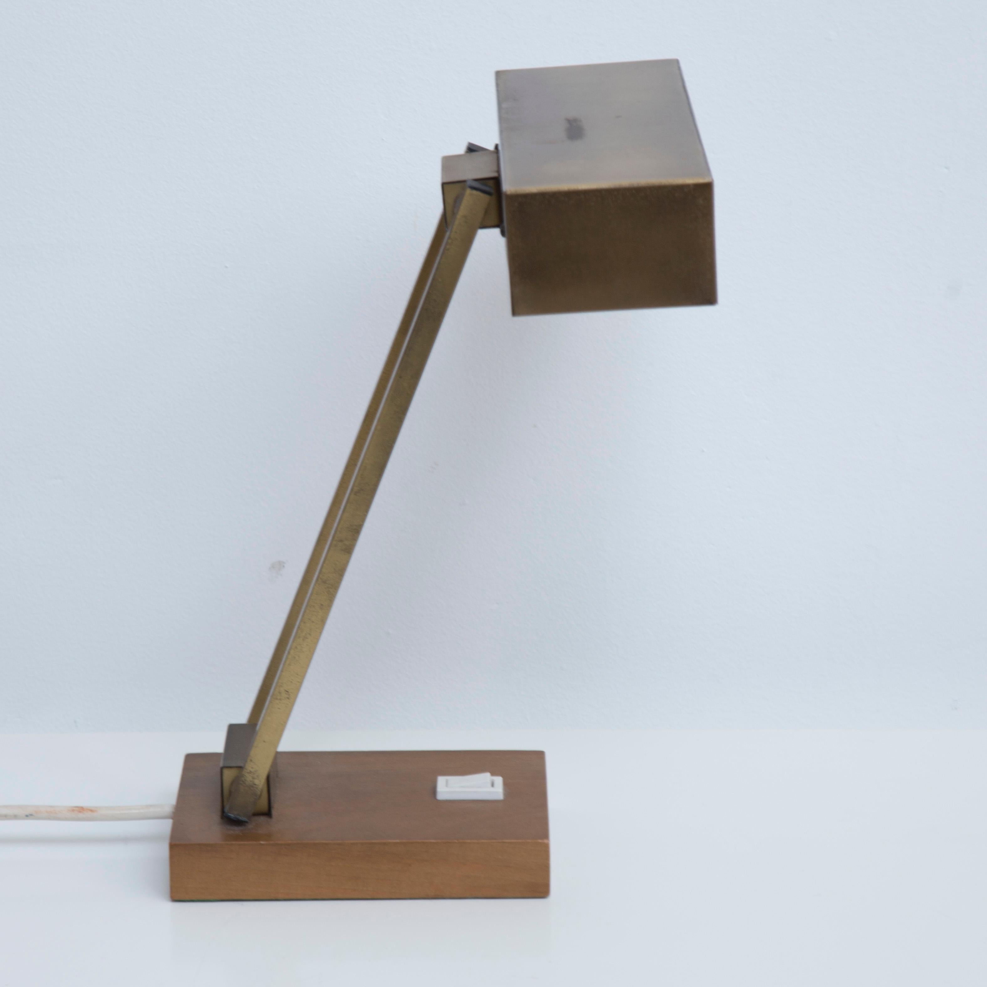 Beautiful desk lamp produced in the 50s. The lamp is adjustable and made of brass and shows a lovely patina. Very nice sculptural lines through the double adjustable arm on a brass base.