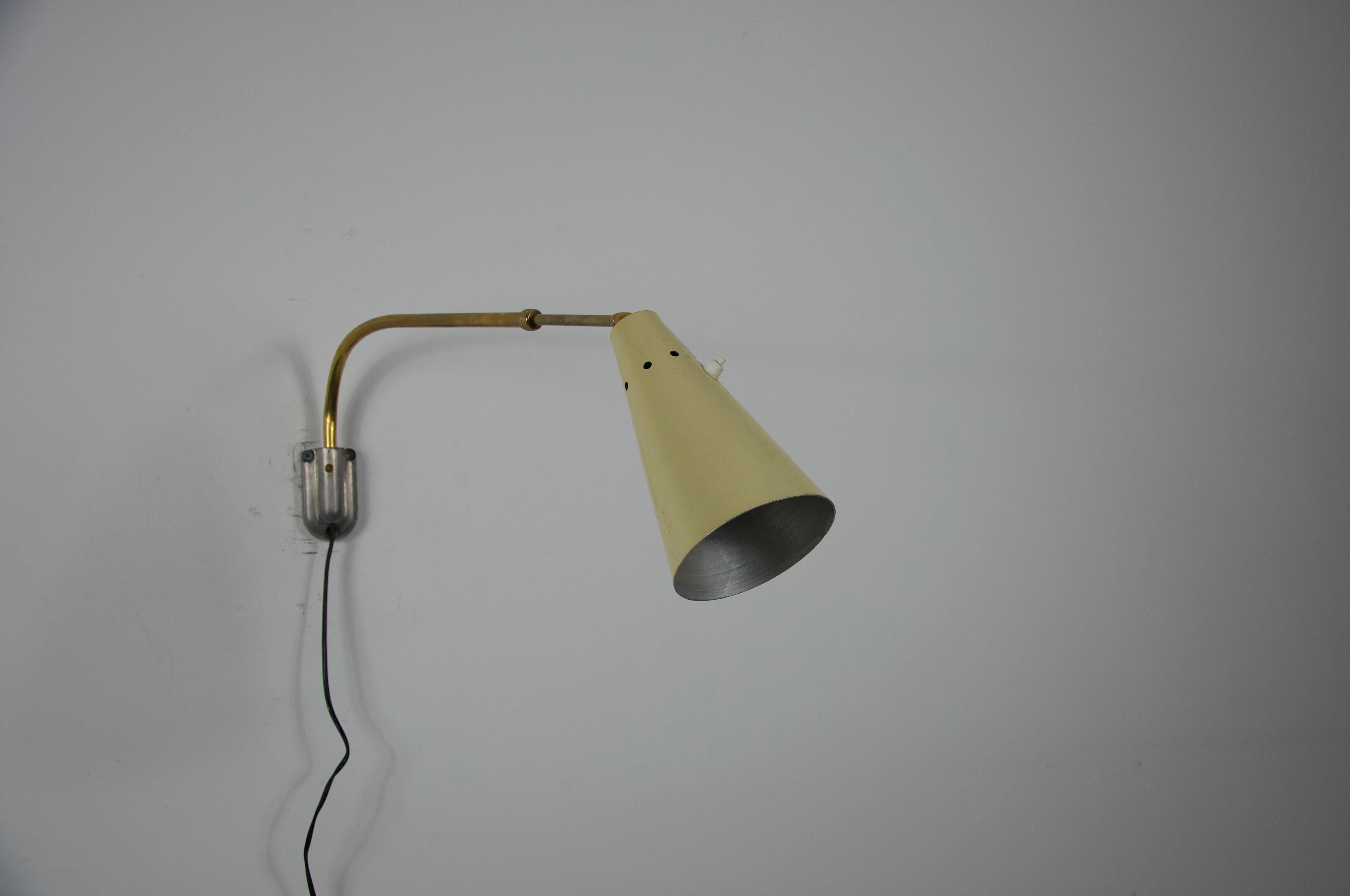 Este elegante aplique regulable de latón, atribuido a Oluce, se fabricó en Italia en la década de 1960. La lámpara presenta un diseño elegante y funcional característico de la iluminación italiana de mediados de siglo. Su brazo extensible de latón