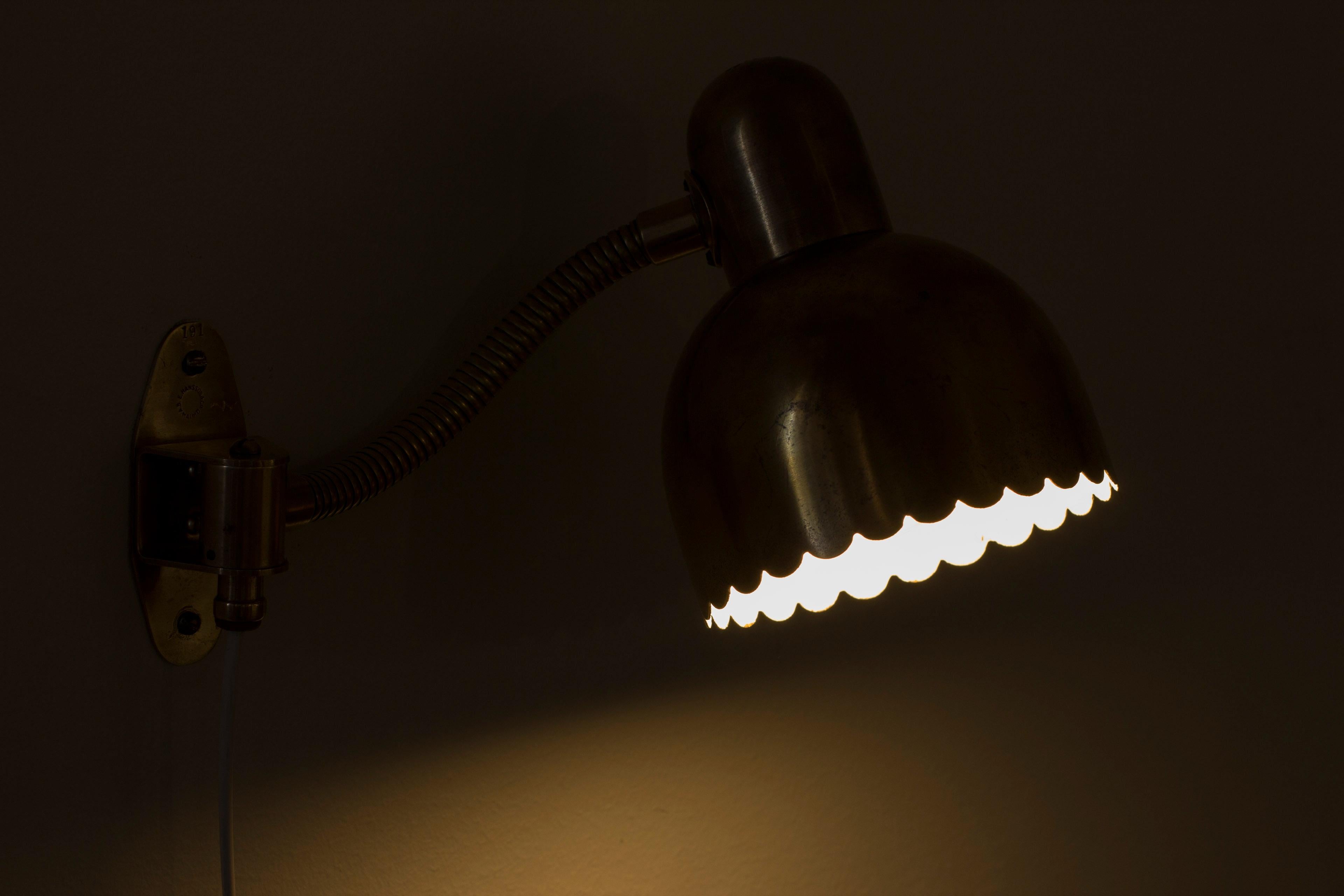 Wall lamp model no 191 by E. Hansson & Co. Produced in Malmö, Sweden during the 1950s. Made from solid brass with shade lacquered white on the inside. Light switch on the chord. Nice details with wavy edge and perforated top of the lamp shade. The