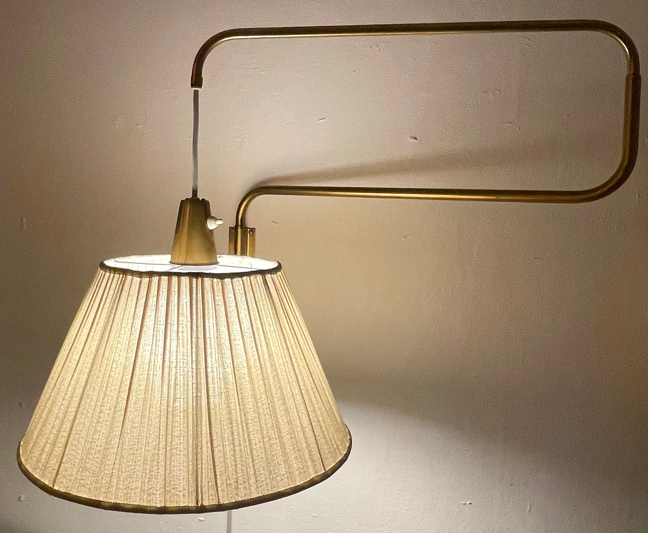 Rare wall lamp attributed to Hans Bergström. Produced during the 1950s by ASEA Belysning with model number E2105. Double brass lamp arm that easily adjusts and can be sprawled. The new, white chord can also be raised or lowered after preference.