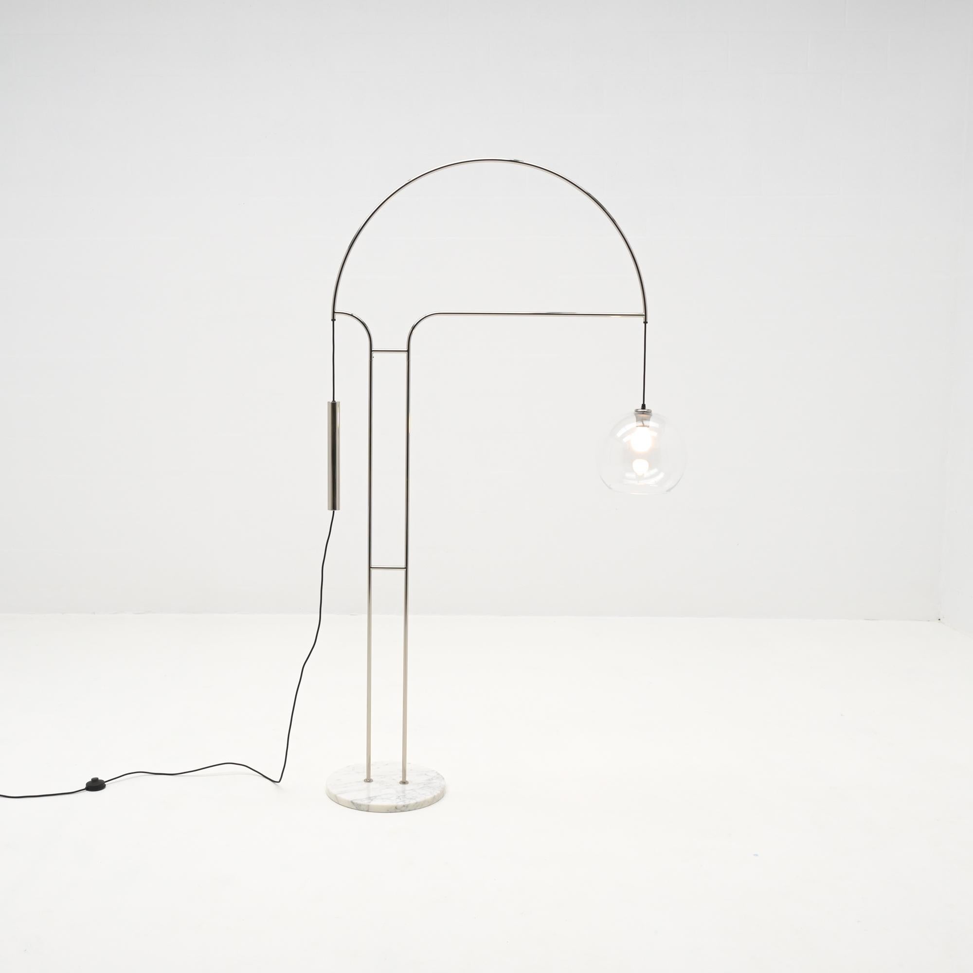 This adjustable arc floor lamp from the 1970s has an elegant chrome tubular stem on a marble base.
The transparent glass sphere has a diameter of 30 cm and is adjustable in height.
It is a special piece in very good authentic condition.