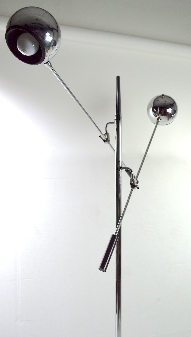 Classic two-arm chrome eyeball floor lamp. Each arm (36 L) will raise and lower, each has an adjustable ball globe, which will pivot to direct and position light. Each arm has an on/off switch, and takes a standard screw in incandescent bulb.