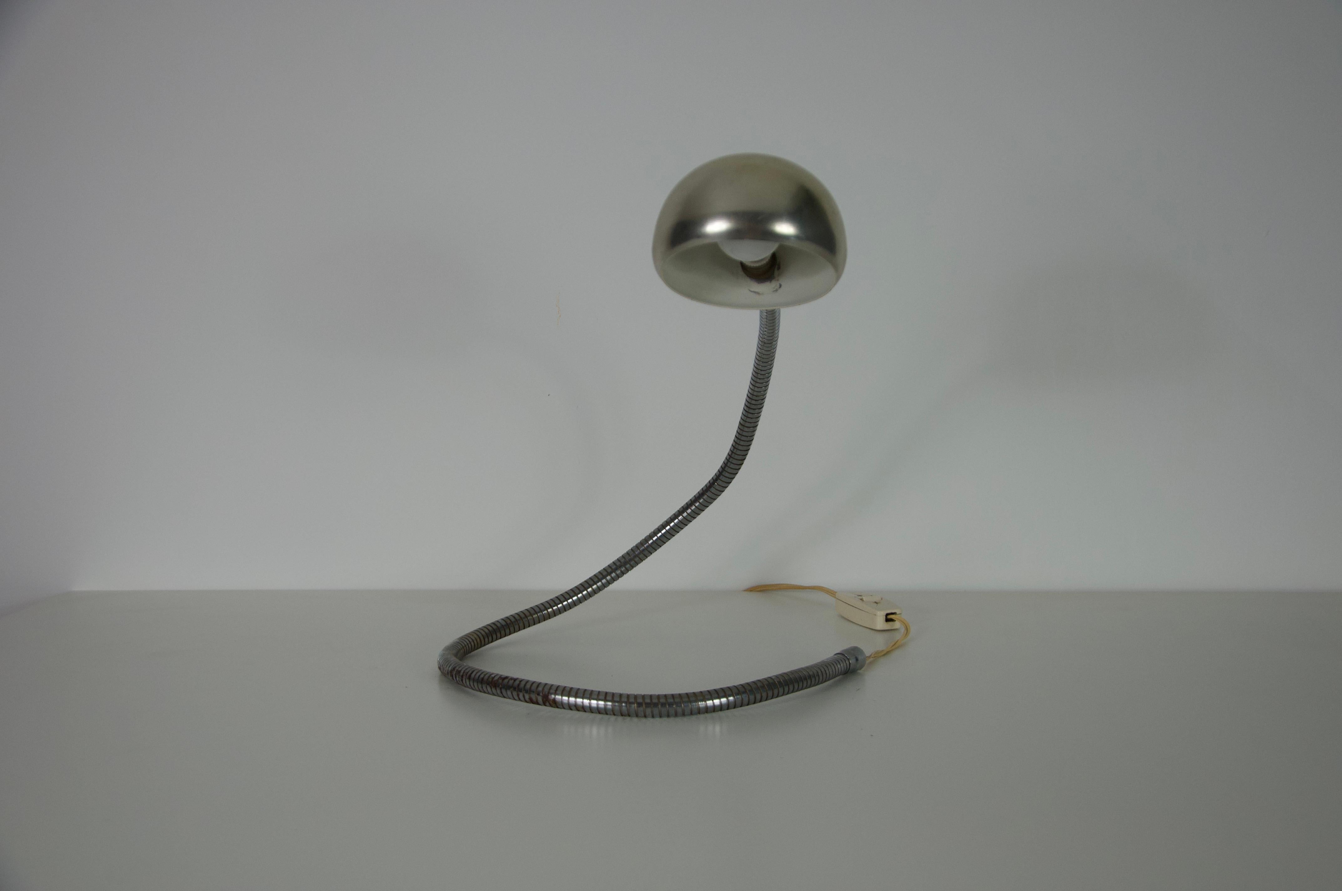 Cette lampe de table à bras flexible réglable en chrome, originaire de l'Italie des années 1960, est une pièce élégante et fonctionnelle du design moderne du milieu du siècle dernier. Son esthétique minimaliste et industrielle est définie par un