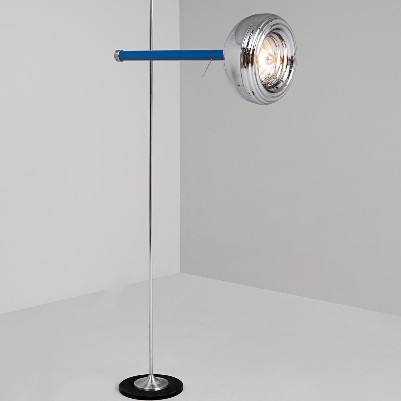 Adjustable floor lamp, in chromed metal, Italy, 1980s.

The well made lamp has a plain base with a chrome vertical stem and an interesting chrome shade. The shade is attached to the vertical base with a horizontal clear blue tube. The corded nut