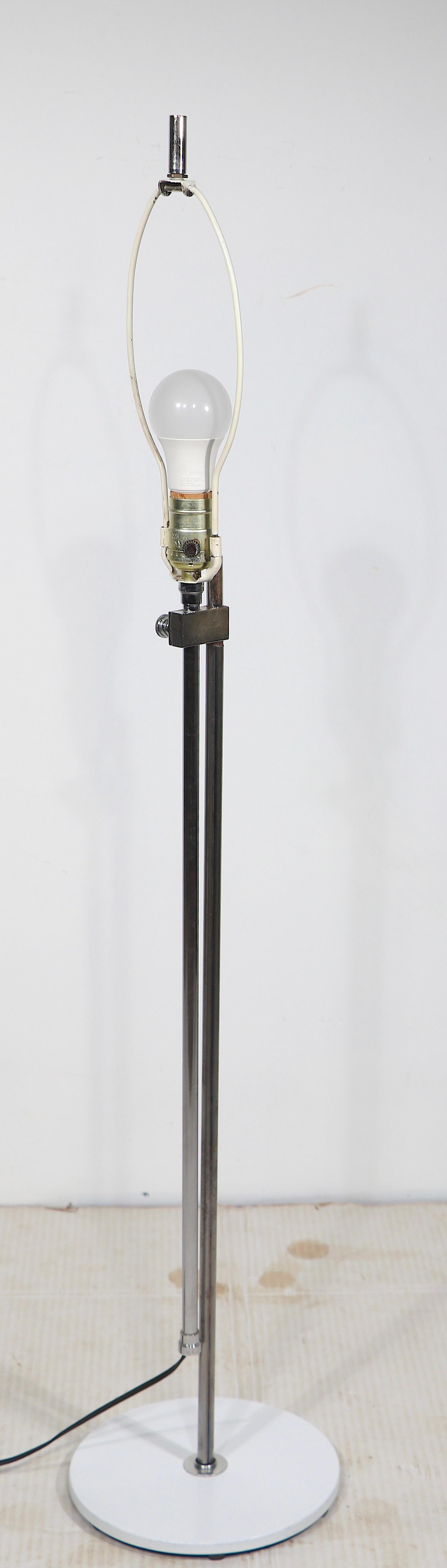 Post Modern chrome and steel adjustable floor lamp, having a painted white round metal base, with two vertical  tubular chrome elements, having a connecting  joint,  which allows the height to be adjusted. In the style of George Kovacs, Robert