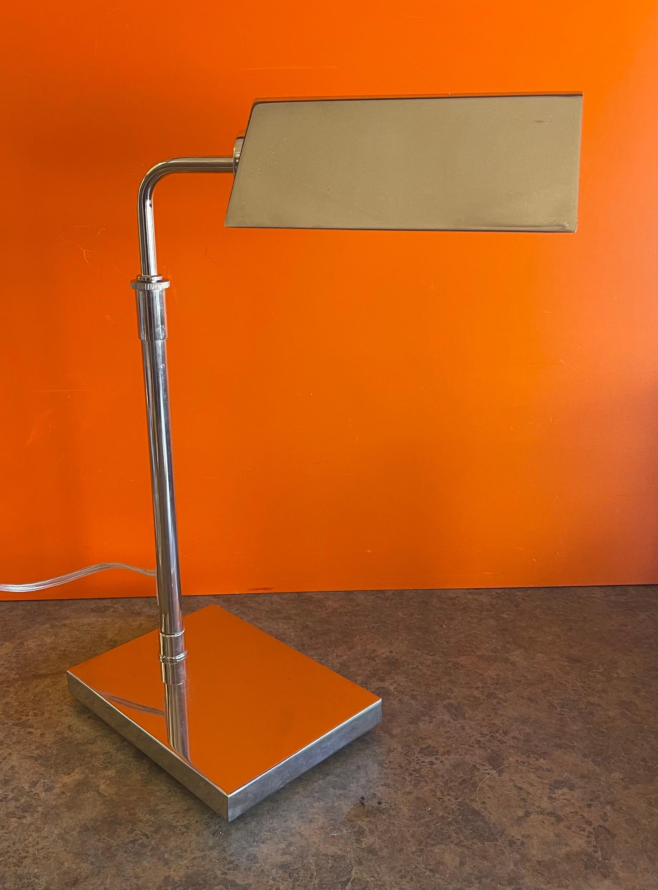 A very nice adjustable chrome pharmacy table lamp with a tented shade by Ralph Lauren, circa 2000s. The telescoping lamp can adjust from 18