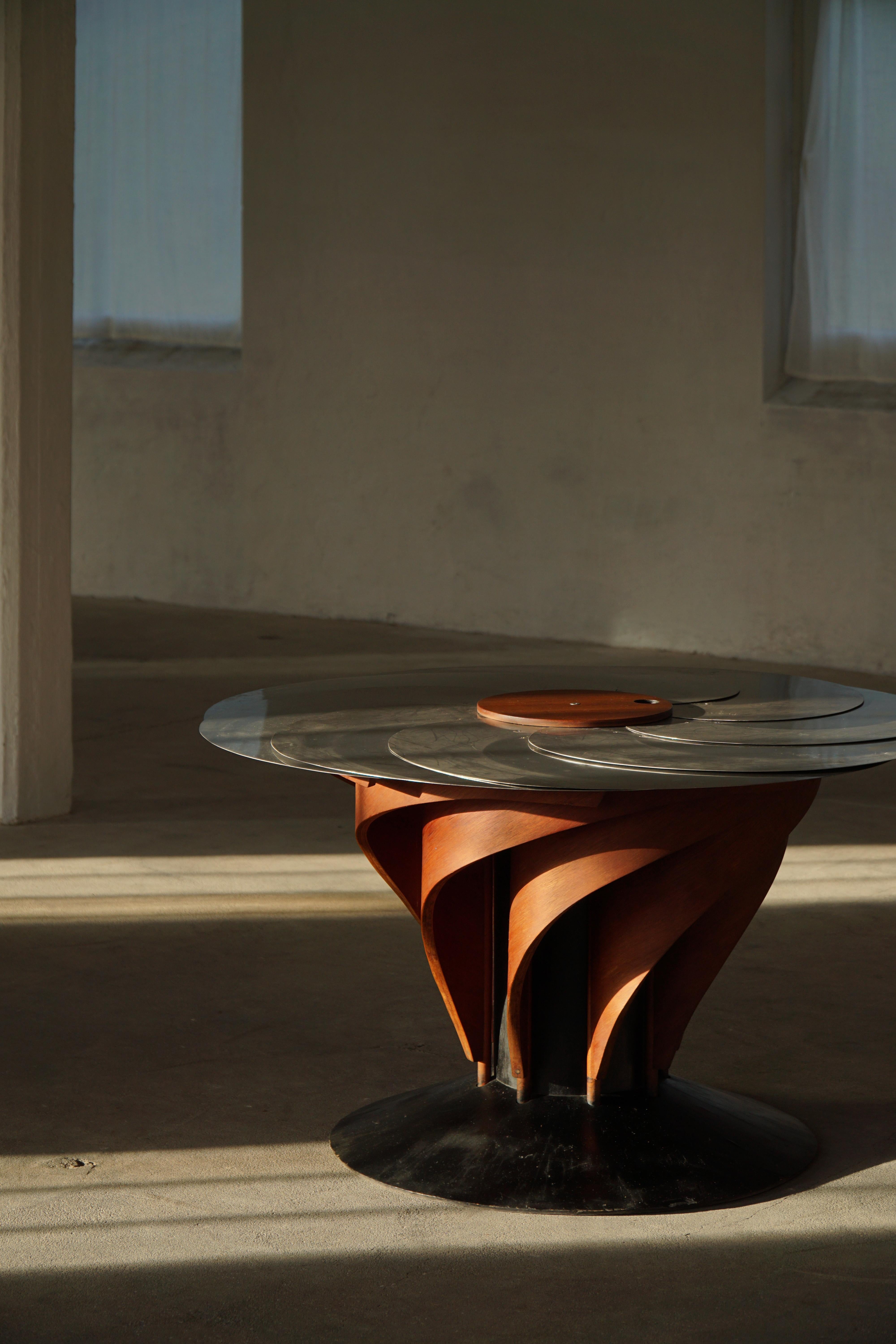 A sculptural and technically sophisticated dining table designed and crafted by Danish designer Nils-Ole Zib in 1990. The model, titled “Iris”, exemplifies Zib’s unique fusion of artistry and engineering.

The table features a mahogany frame with