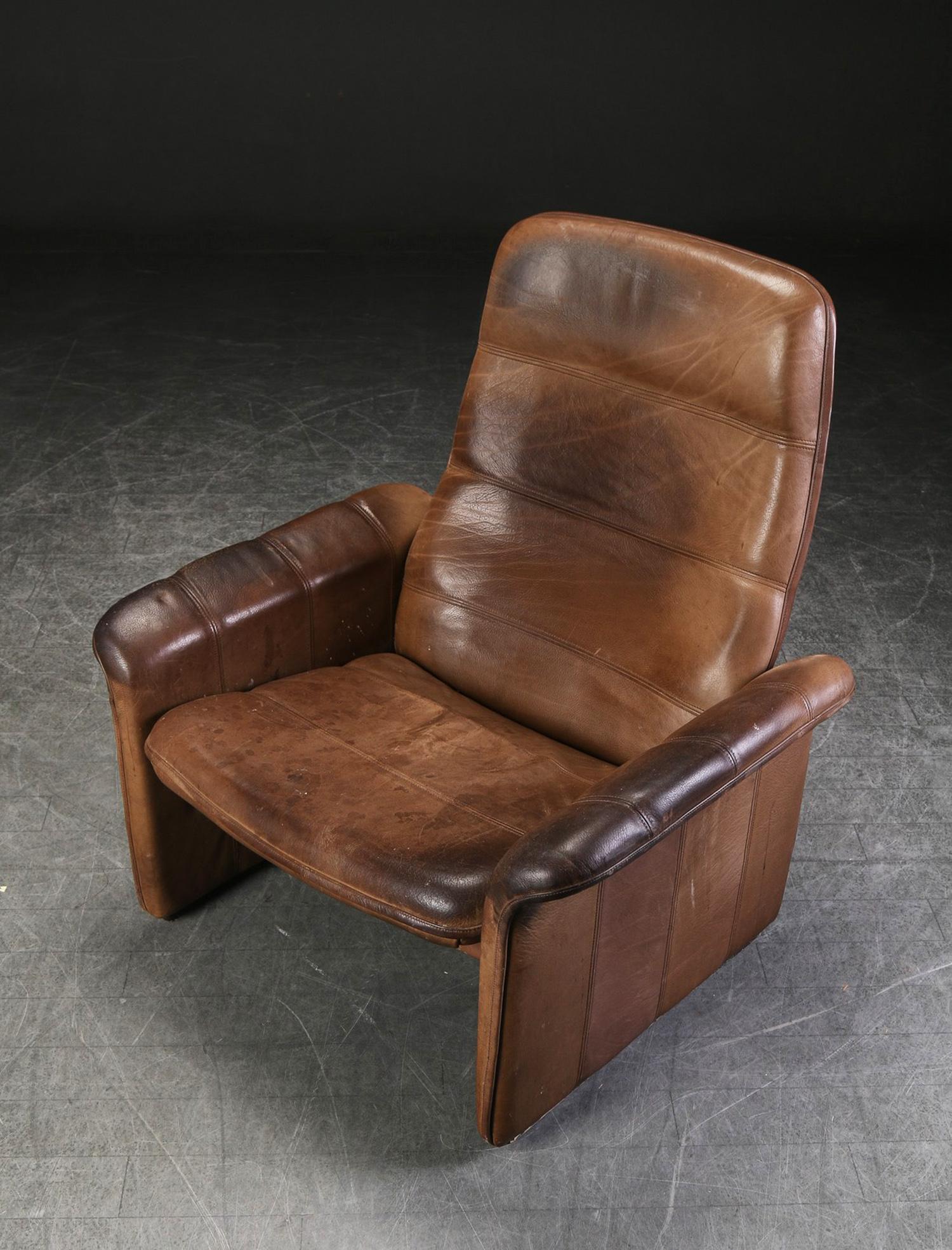 Heavy wood/steel adjustable construction covered with brown buffalo leather. Manufactured in Switzerland by De Sede in the early 1960s. 
Original used condition with great patina.