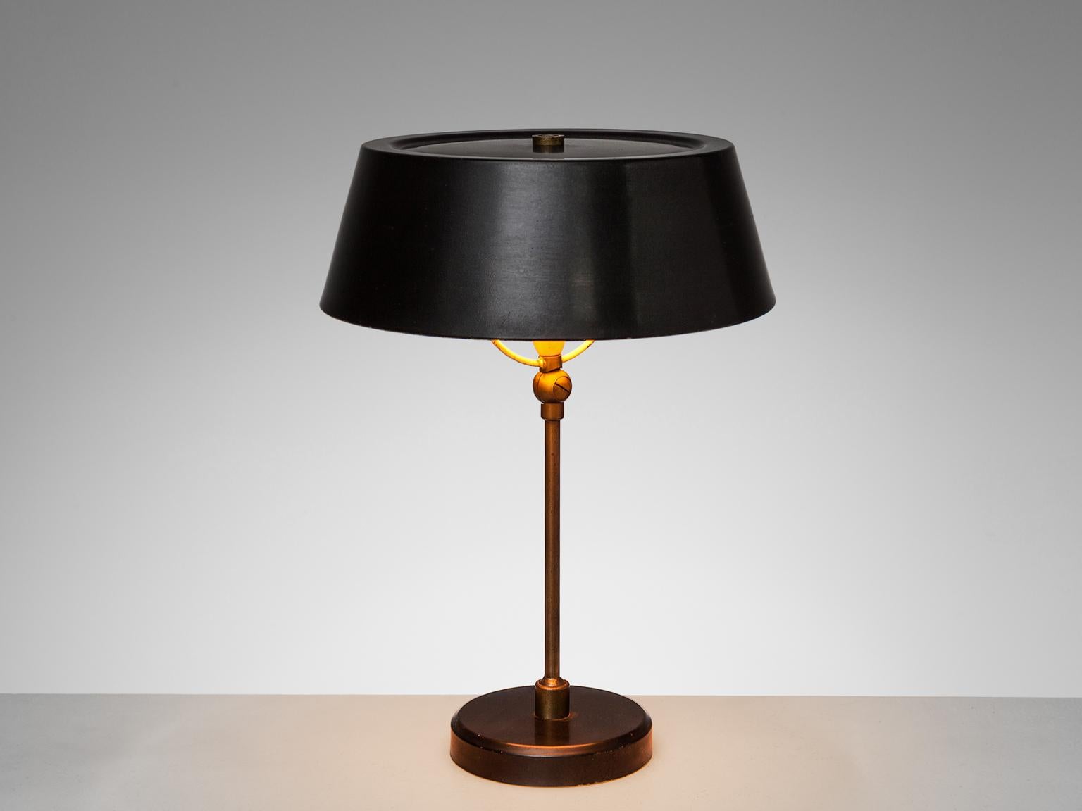 Stilux Milano, desk lamp made with thin black painted steel and brass, Italy, 1950s.

Stylish desk light with black round shade. The circular shade matches the dark base and is connected by a brass stem. The base is made in a dark metal on which the