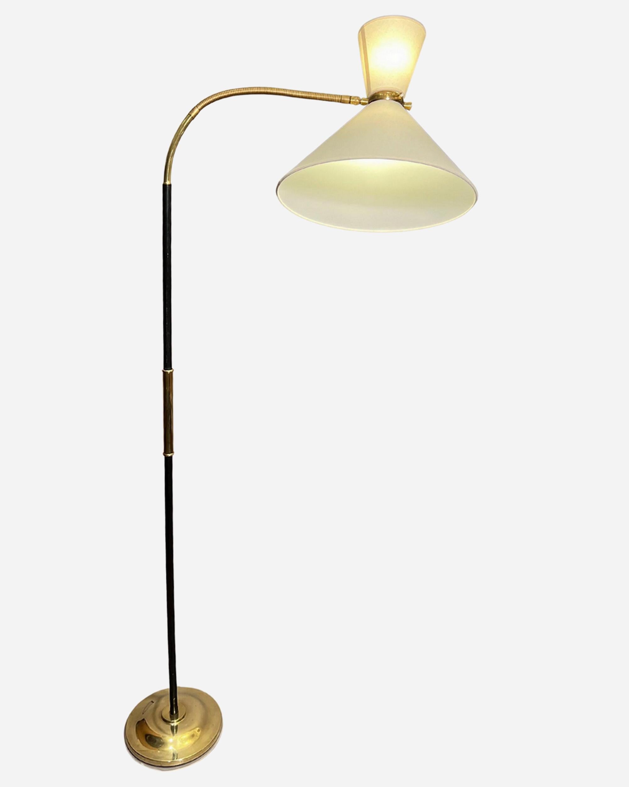 Double-light “diabolo” floor lamp by Maison Lunel.
The polished brass and lacquered metal shaft supports an articulated arm terminating in a ball-and-socket joint to which the double lampshade is attached.
Polished brass base weighted by a cast-iron