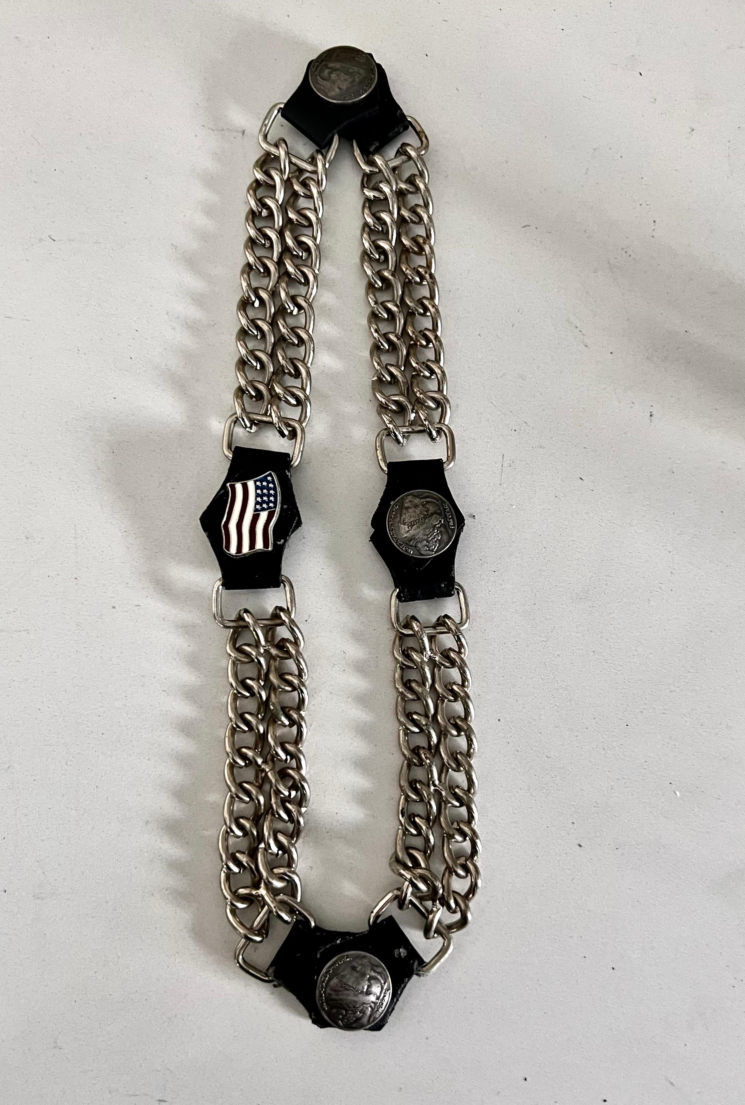 A substantial statement piece for pets or humans. Likely a relic of American biker culture. 

Metal and leather dog collar with buffalo nickels and a 13-star U.S. flag detail. Collar measures 24 inches total length, a series of 4 inch adjustable