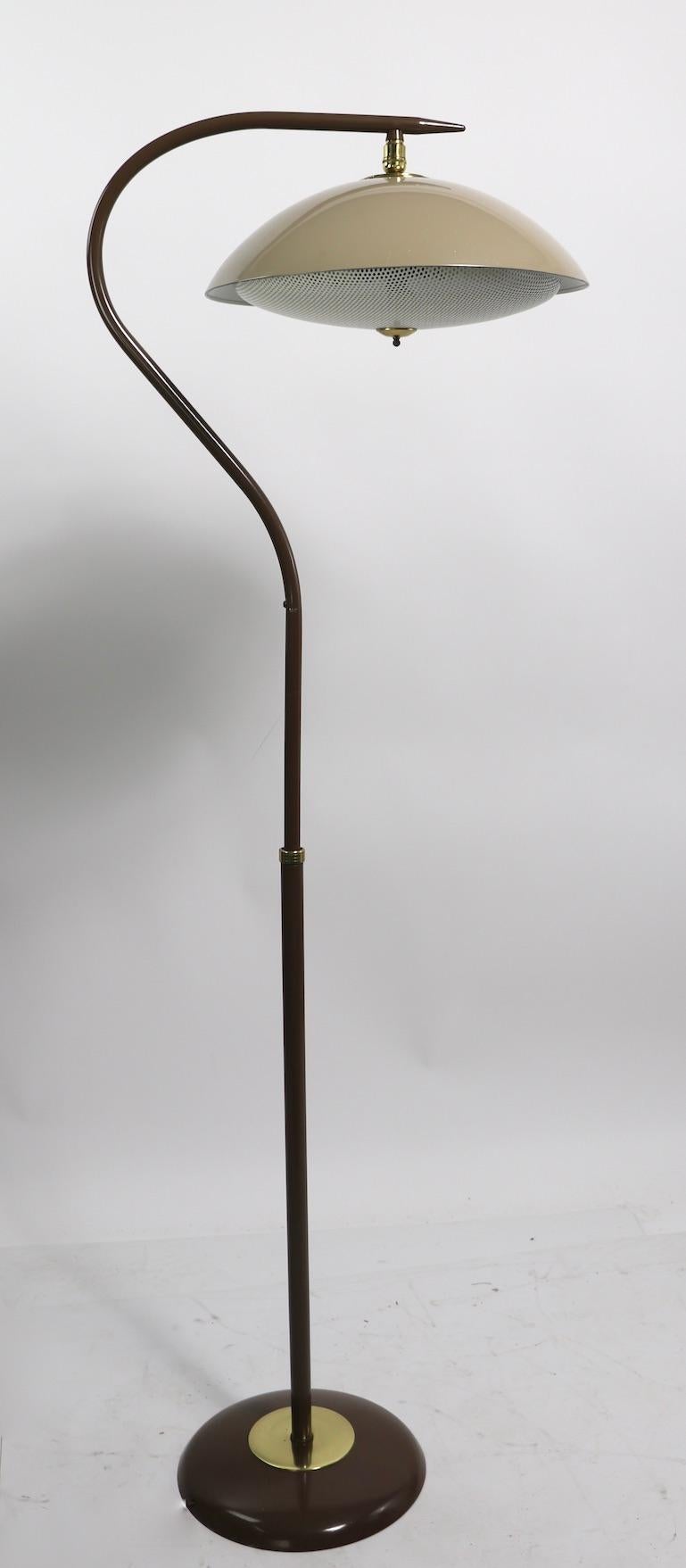 Very sexy adjustable floor, or reading lamp designed by Gerald Thurston for Lightolier. This example has a swivel, tilt disk shade (shade 14 in. diameter.) which is attached to a curved arm that can be adjusted in height ( H 57 in x L 46 in. )